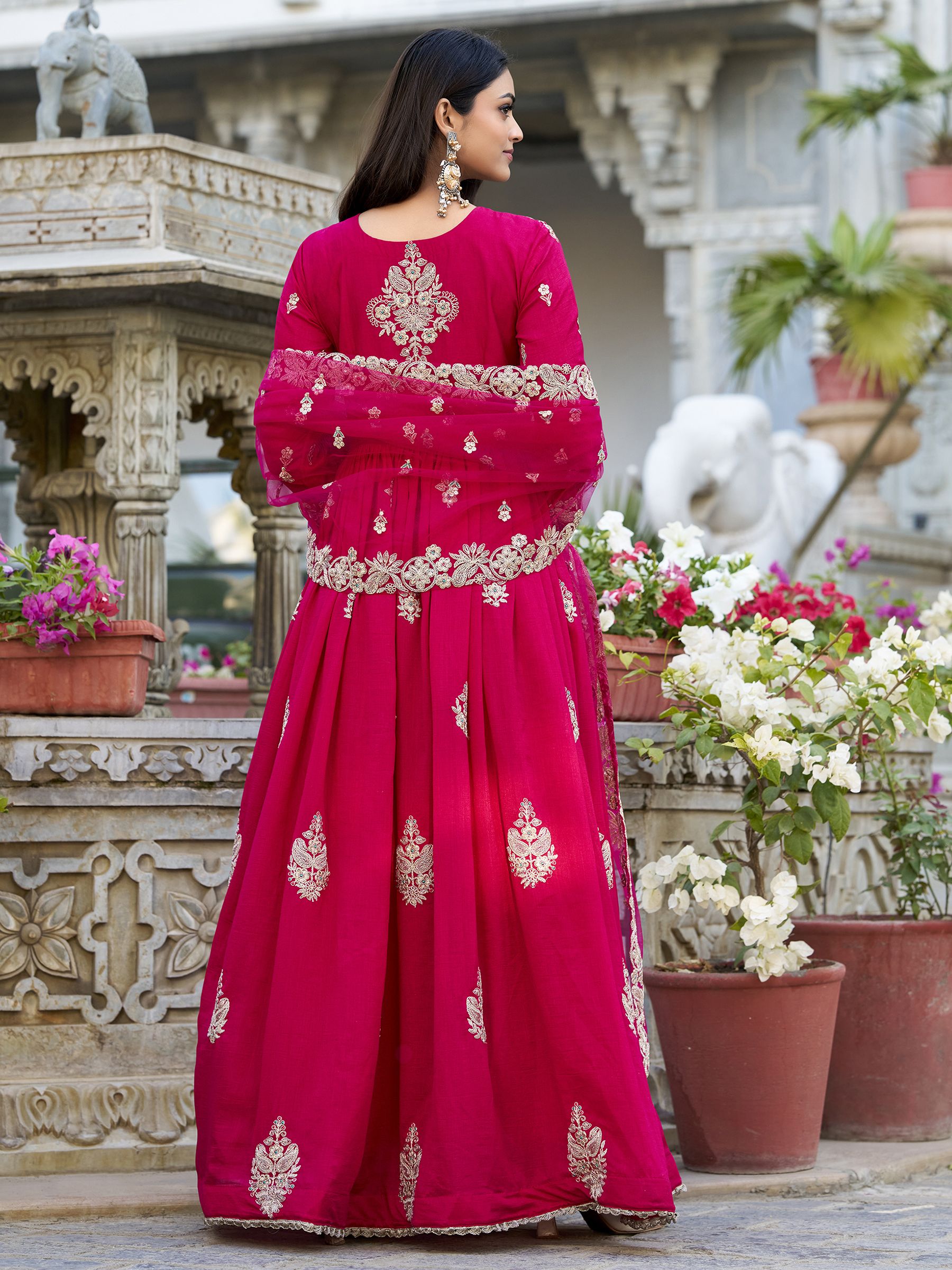 Anwitha Pink Embroidered Silk Anarkali Gown Set, crafted from luxurious Vichitra Silk with intricate sequins and thread embroidery accented by delicate lace details. This fully stitched Anarkali gown features a 3-meter flair and a soft cotton lining for comfort. Paired with a graceful net dupatta adorned with sequins embroidery and a lace border, this elegant ensemble is perfect for weddings, festive occasions, and grand celebrations