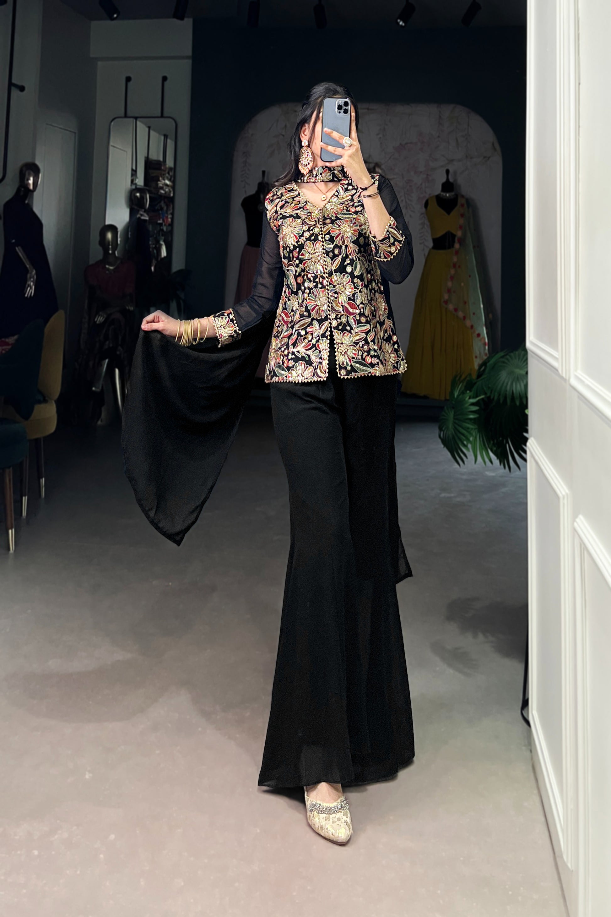 Kanvika Black Kurta Palazzo Set crafted from premium georgette fabric, featuring a short embroidered kurta with sequins and thread embroidery, full sleeves, and a soft micro cotton lining. Paired with plain georgette palazzo pants with an elastic waistband for comfort and a lightweight embroidered georgette dupatta. Ideal for festive wear, party wear, and wedding functions, this elegant ethnic ensemble blends tradition with contemporary sophistication
