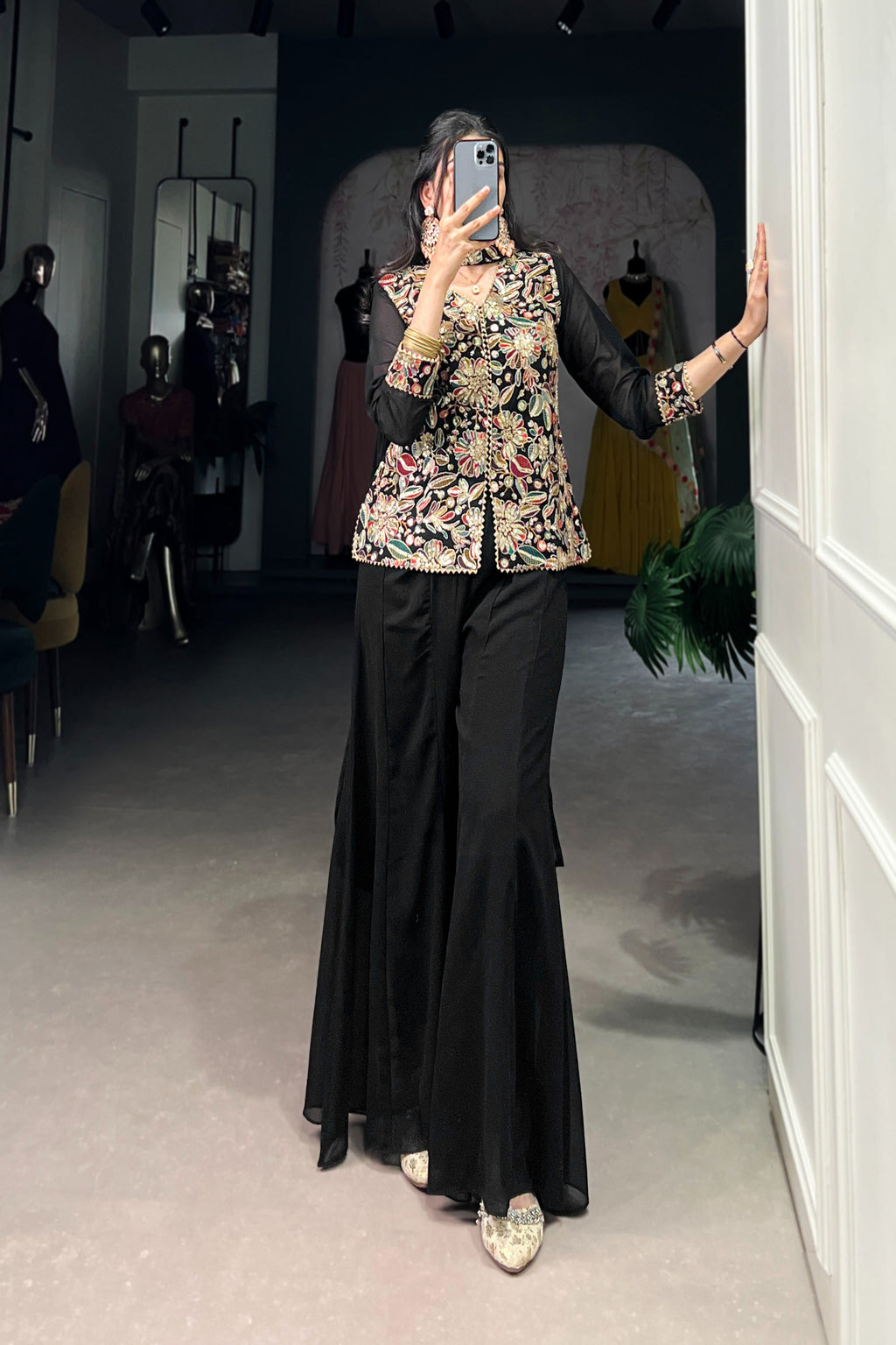 Kanvika Black Kurta Palazzo Set crafted from premium georgette fabric, featuring a short embroidered kurta with sequins and thread embroidery, full sleeves, and a soft micro cotton lining. Paired with plain georgette palazzo pants with an elastic waistband for comfort and a lightweight embroidered georgette dupatta. Ideal for festive wear, party wear, and wedding functions, this elegant ethnic ensemble blends tradition with contemporary sophistication