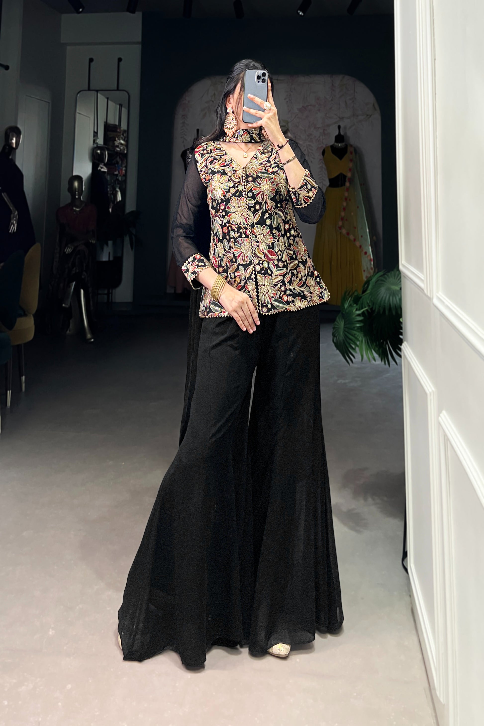 Kanvika Black Kurta Palazzo Set crafted from premium georgette fabric, featuring a short embroidered kurta with sequins and thread embroidery, full sleeves, and a soft micro cotton lining. Paired with plain georgette palazzo pants with an elastic waistband for comfort and a lightweight embroidered georgette dupatta. Ideal for festive wear, party wear, and wedding functions, this elegant ethnic ensemble blends tradition with contemporary sophistication