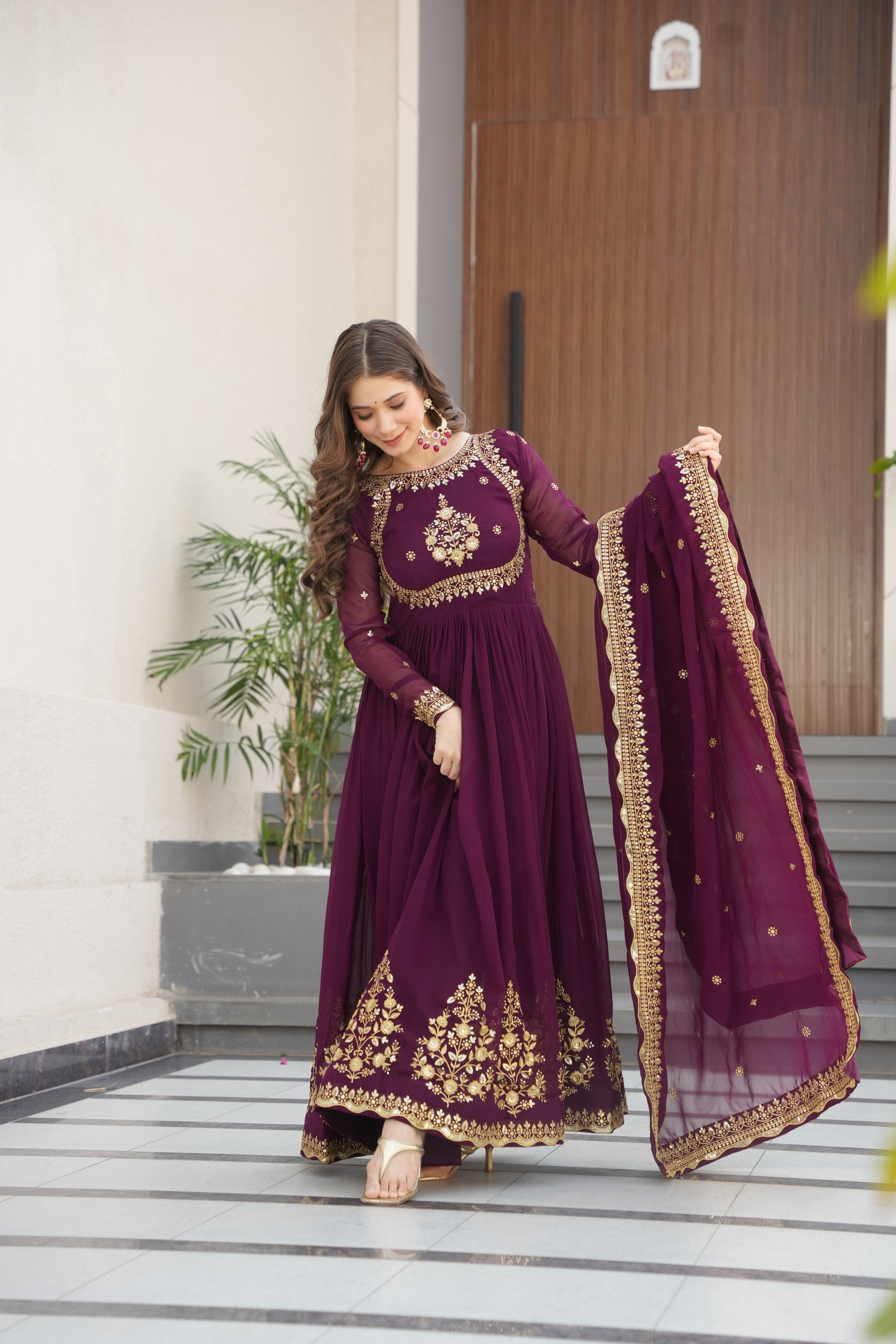 Wine-colored embroidered Anarkali gown set for women with dupatta, luxurious ethnic outfit featuring intricate zari and sequin embroidery, full-length party wear Anarkali with flared silhouette and elegant neckline, ideal for weddings, festive celebrations, and traditional Indian occasions, readymade stitched gown for 2025 designer ethnic fashion trends.