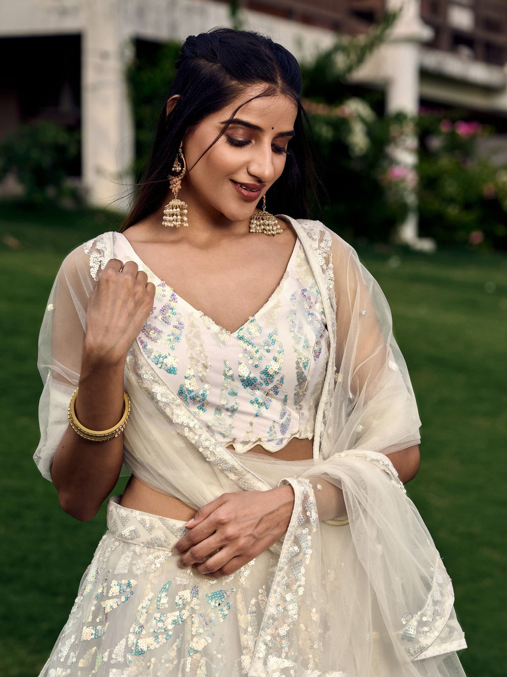 Off white net sequins embroidered party wear lehenga choli