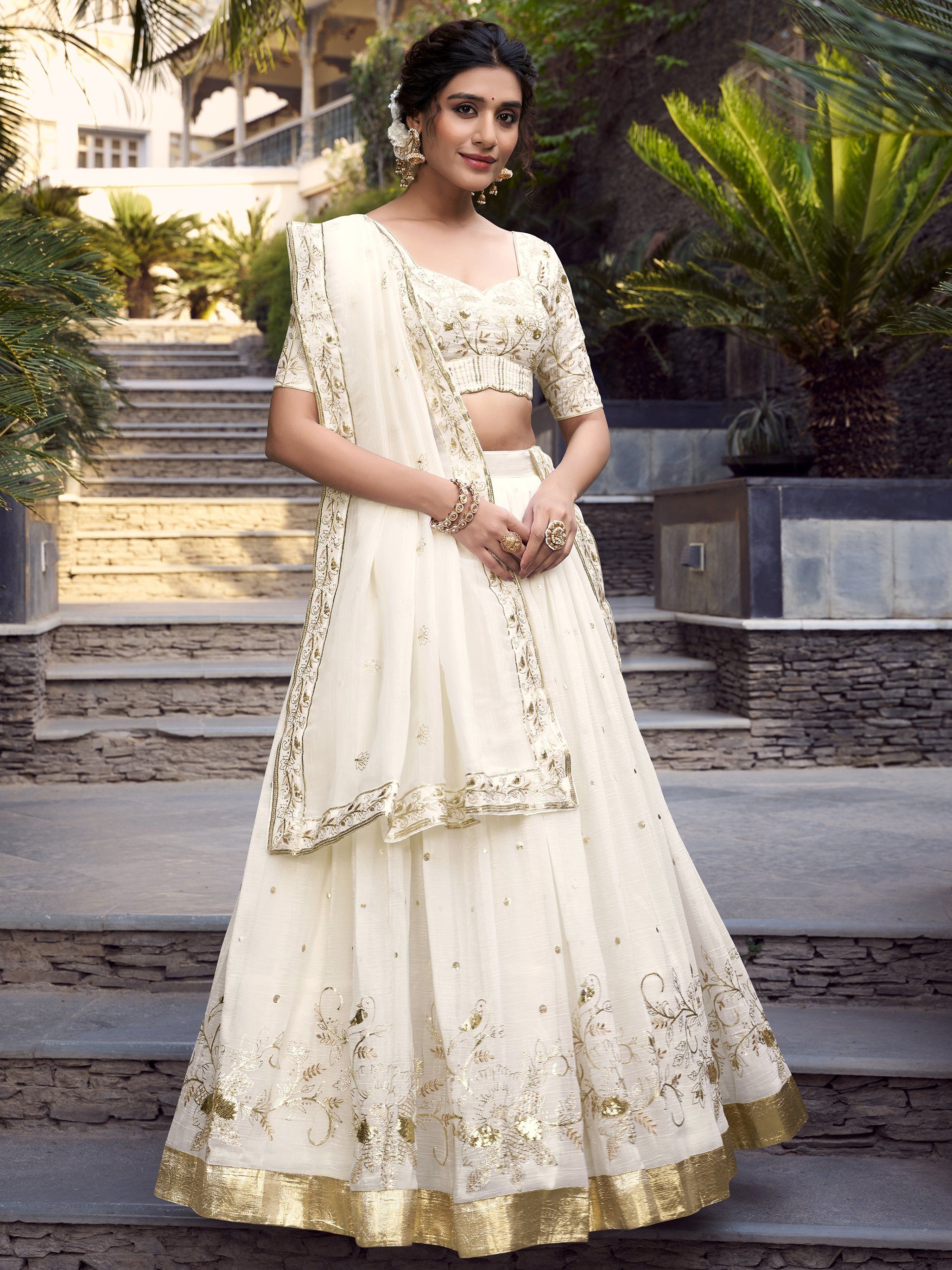 Off-white silver glossy lehenga choli set with sequin, embroidery, and foil work; includes 3.5-meter flared lehenga, unstitched blouse, and embroidered dupatta – perfect for weddings and festive events