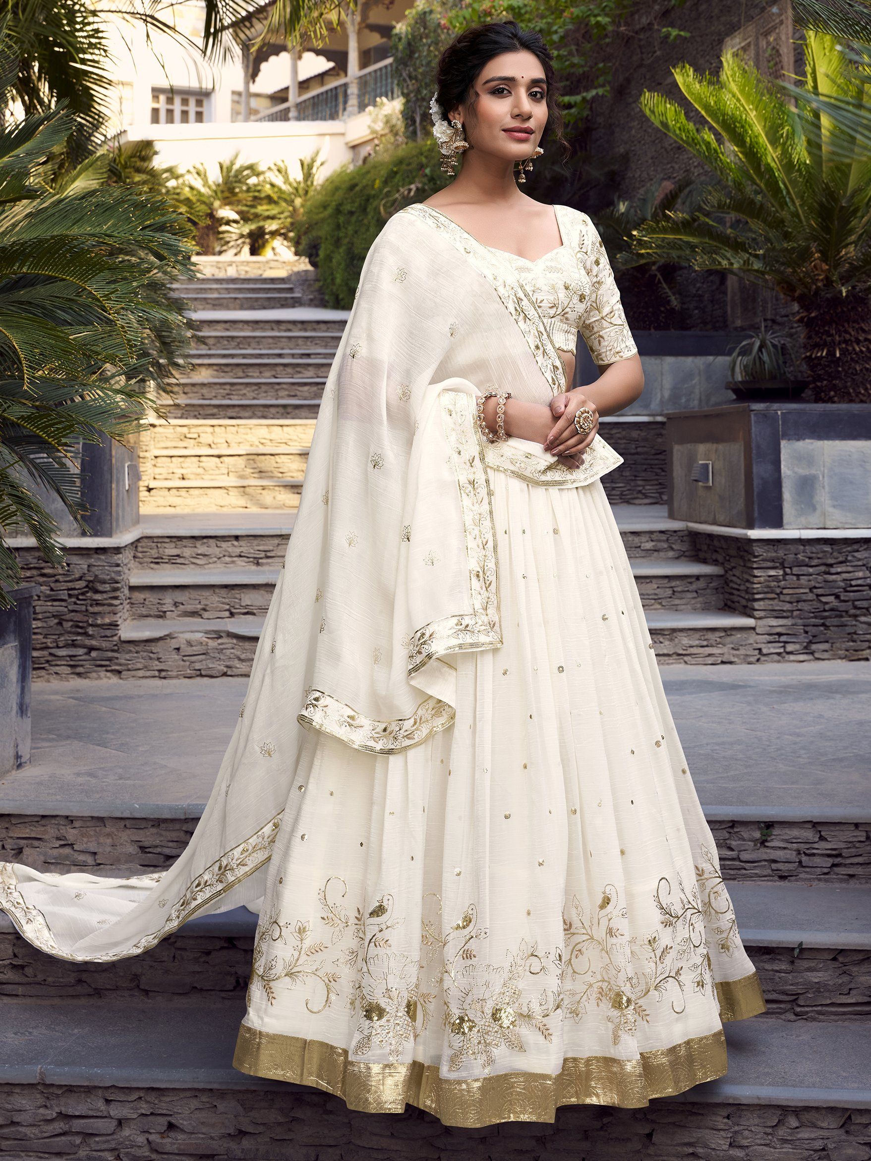 Off-white silver glossy lehenga choli set with sequin, embroidery, and foil work; includes 3.5-meter flared lehenga, unstitched blouse, and embroidered dupatta – perfect for weddings and festive events