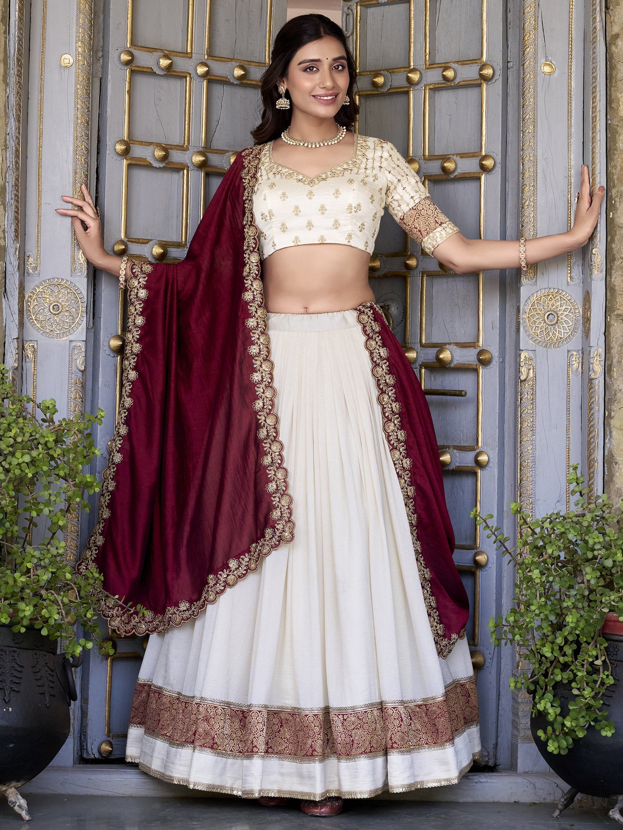 Off-white Vichitra silk lehenga choli set featuring zari weaving, sequins lace border, and embroidered dupatta ideal for weddings and festive celebrations.