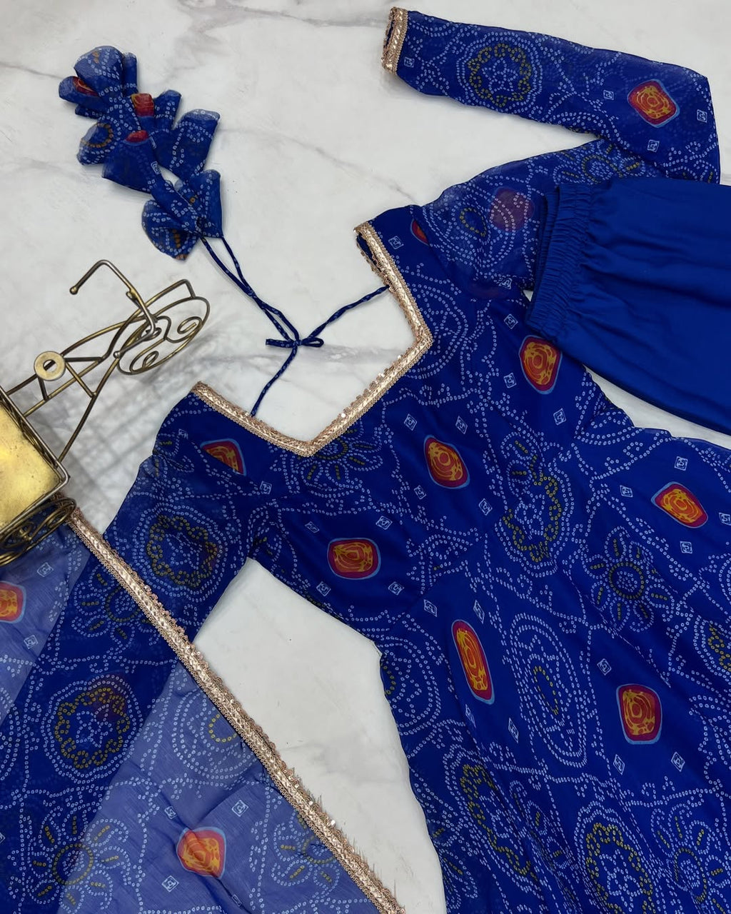 Shanvi Bandhej Chiffon Anarkali Suit Set – blue Bandhej Anarkali gown, traditional chiffon ethnic wear, women’s blue ethnic dress, Bandhej printed Anarkali for weddings, designer ethnic gown, Anarkali suit with lace dupatta, flair Anarkali with full sleeves, Bandhej print ethnic dress, blue festival wear gown, Indian wedding guest Anarkali.