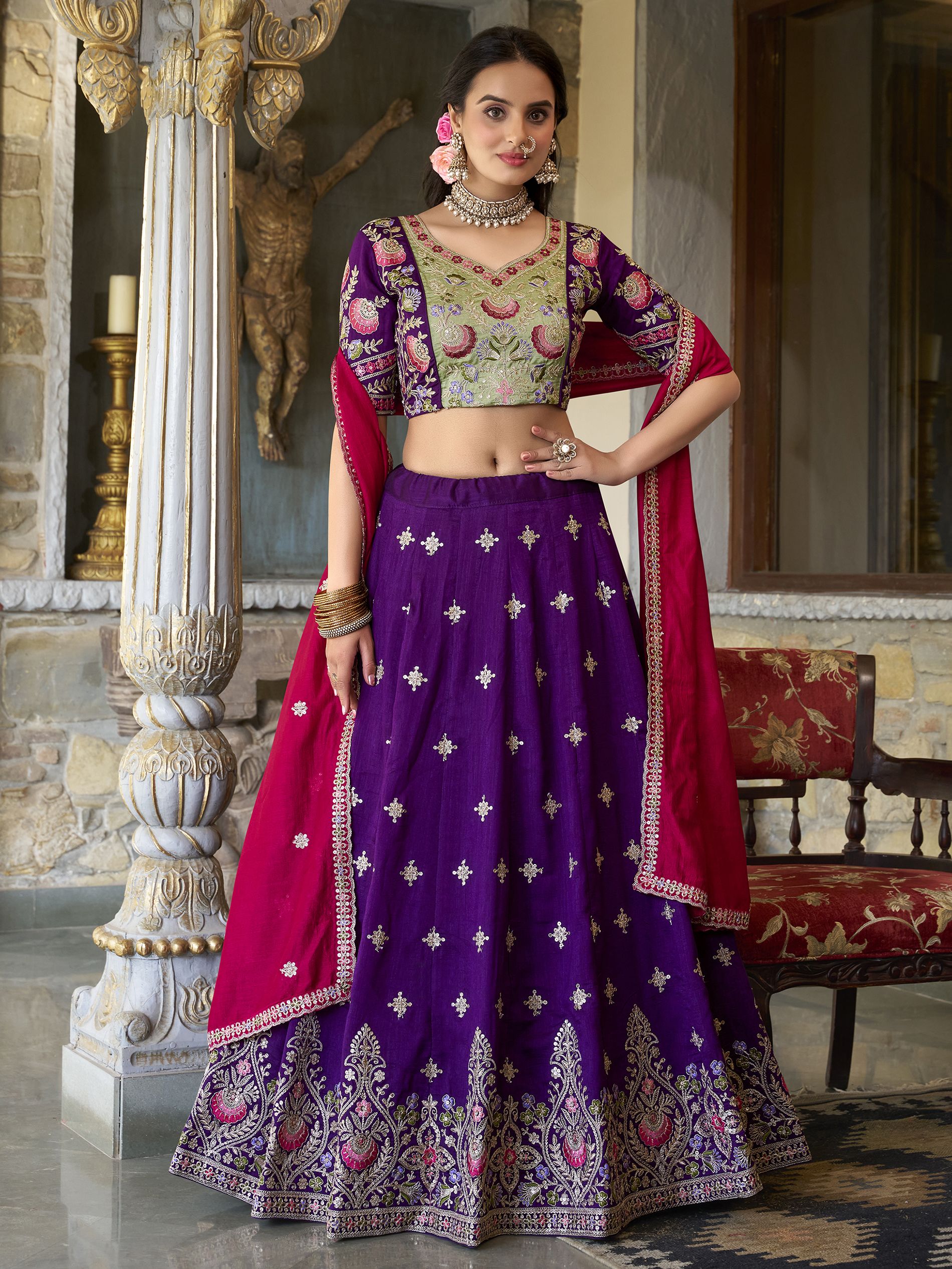 Suamya Purple Vichitra Silk Embroidered Lehenga Choli, featuring exquisite sequins and thread embroidery on luxurious Vichitra silk. The fully stitched lehenga comes with a 3-meter flair, canvas, and cancan for volume, paired with an unstitched blouse fabric for a customizable fit. The matching dupatta is adorned with sequins, embroidery, and a lace border. Perfect for weddings, festive celebrations, and grand occasions, this elegant ensemble blends sophistication with tradition