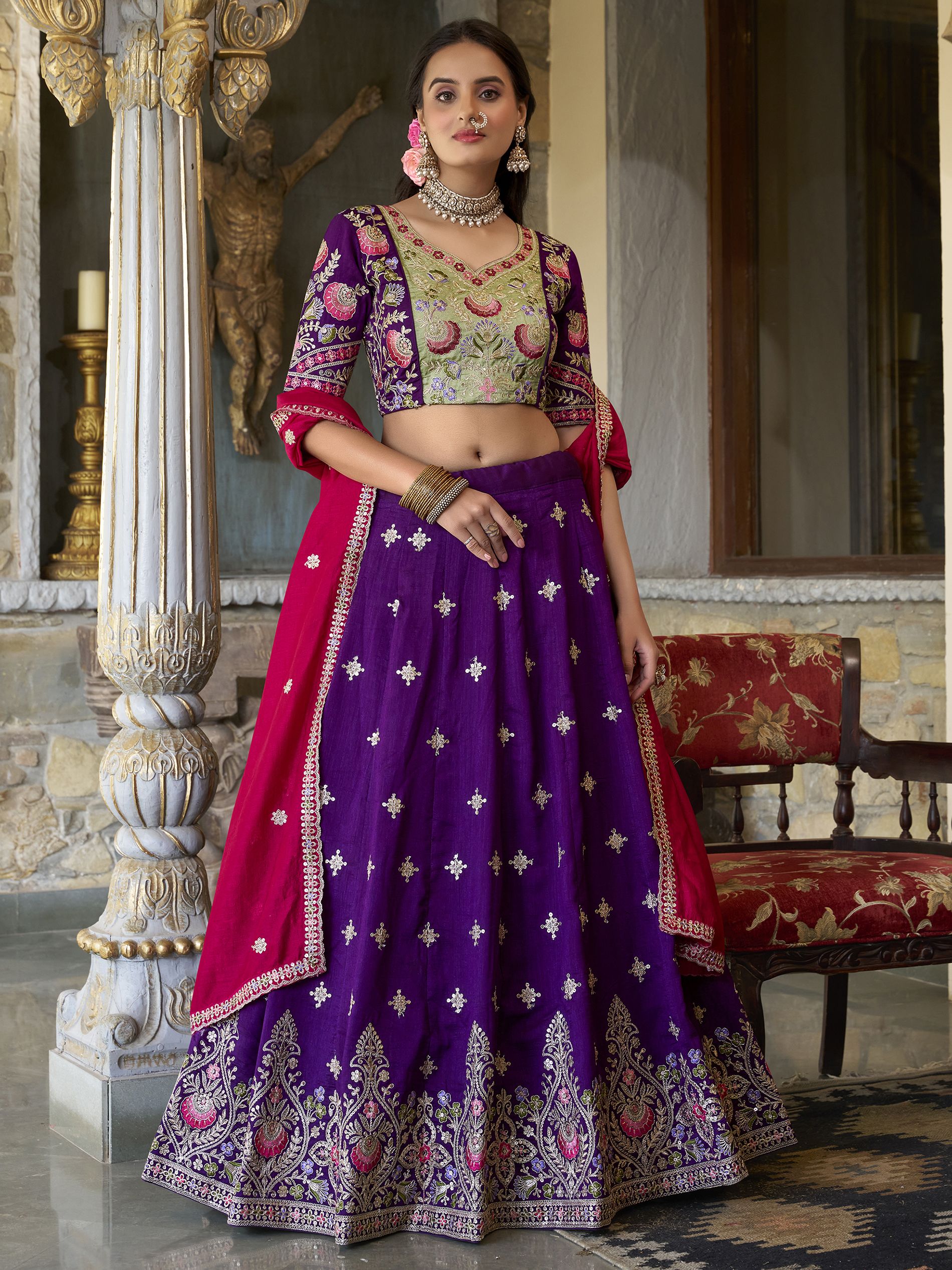 Suamya Purple Vichitra Silk Embroidered Lehenga Choli, featuring exquisite sequins and thread embroidery on luxurious Vichitra silk. The fully stitched lehenga comes with a 3-meter flair, canvas, and cancan for volume, paired with an unstitched blouse fabric for a customizable fit. The matching dupatta is adorned with sequins, embroidery, and a lace border. Perfect for weddings, festive celebrations, and grand occasions, this elegant ensemble blends sophistication with tradition