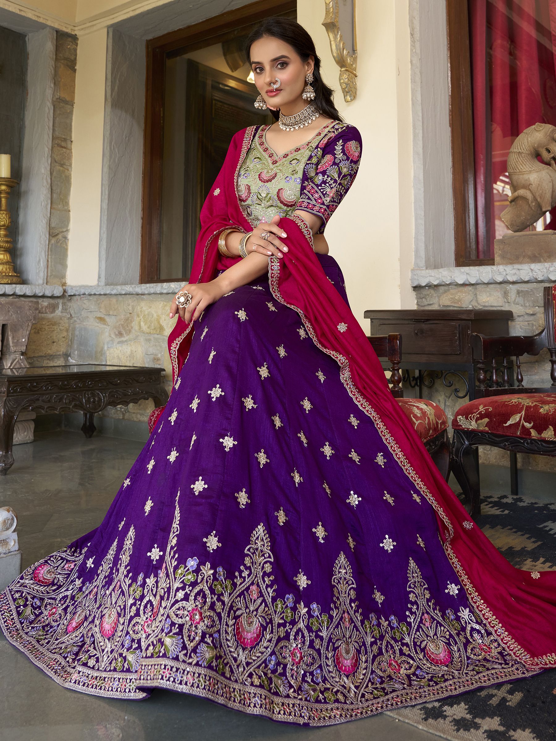 Suamya Purple Vichitra Silk Embroidered Lehenga Choli, featuring exquisite sequins and thread embroidery on luxurious Vichitra silk. The fully stitched lehenga comes with a 3-meter flair, canvas, and cancan for volume, paired with an unstitched blouse fabric for a customizable fit. The matching dupatta is adorned with sequins, embroidery, and a lace border. Perfect for weddings, festive celebrations, and grand occasions, this elegant ensemble blends sophistication with tradition