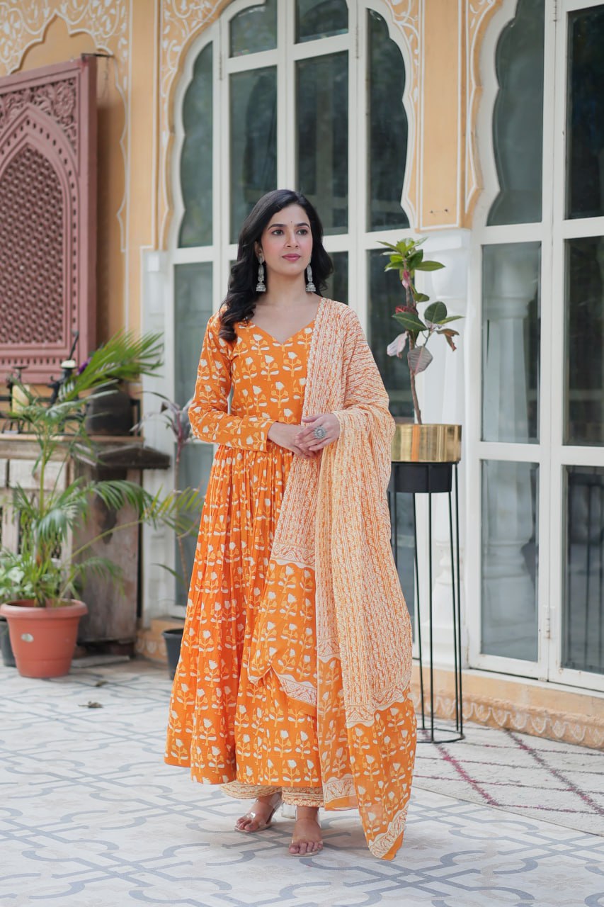 The Ridhvini Orange Pure Cotton Printed Anarkali Set is a stylish and breathable cotton Anarkali suit for women, perfect for daily wear, office wear, and festive occasions. Made from premium pure cotton, this readymade Anarkali kurta set offers comfort and elegance with a flowing silhouette, fancy V-neck, and full sleeves. Paired with straight cotton pants and a matching dupatta, this ethnic cotton suit is ideal for summer fashion. Whether you're looking for a lightweight festive outfit or a printed Anarkal
