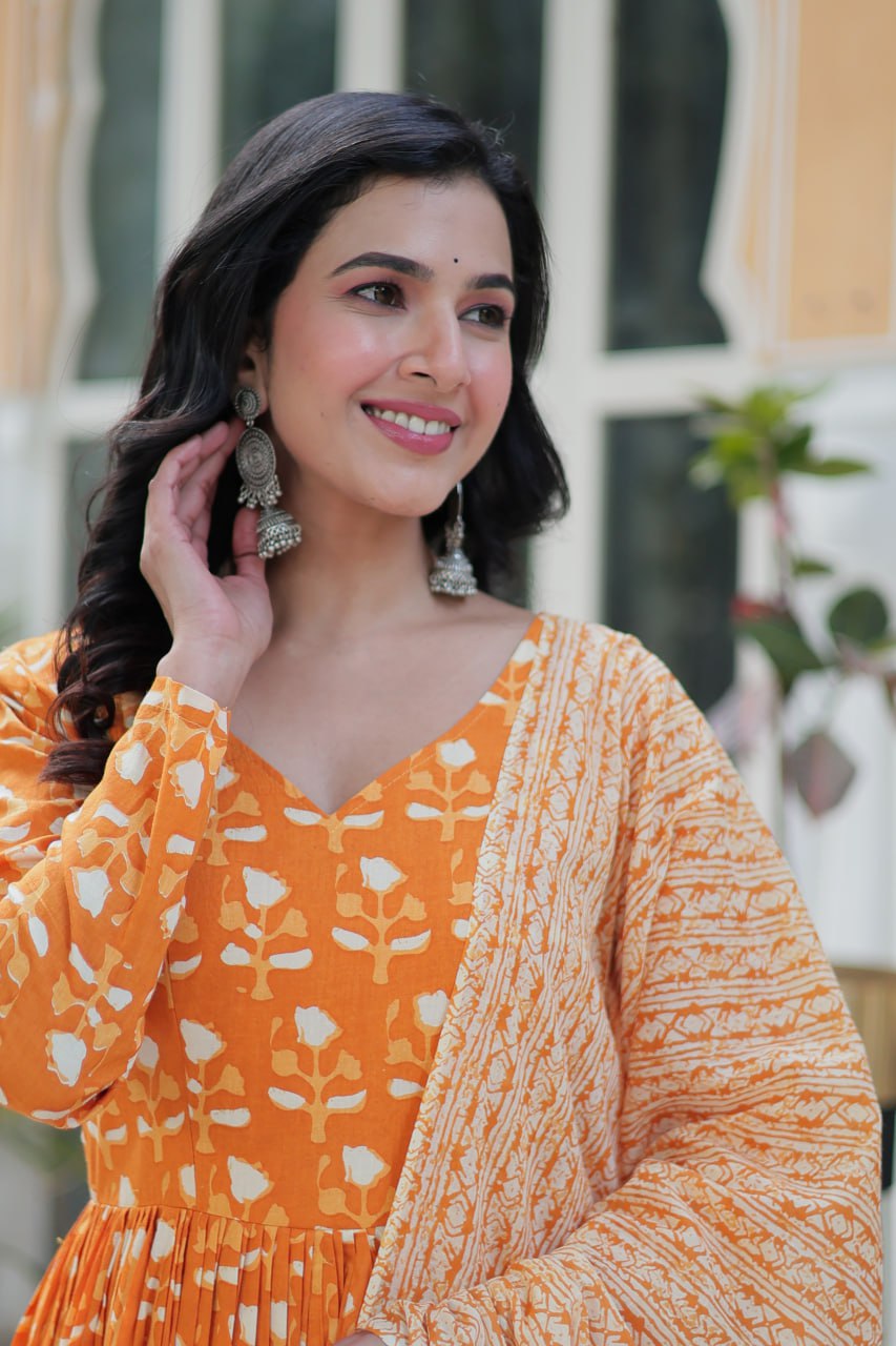 The Ridhvini Orange Pure Cotton Printed Anarkali Set is a stylish and breathable cotton Anarkali suit for women, perfect for daily wear, office wear, and festive occasions. Made from premium pure cotton, this readymade Anarkali kurta set offers comfort and elegance with a flowing silhouette, fancy V-neck, and full sleeves. Paired with straight cotton pants and a matching dupatta, this ethnic cotton suit is ideal for summer fashion. Whether you're looking for a lightweight festive outfit or a printed Anarkal