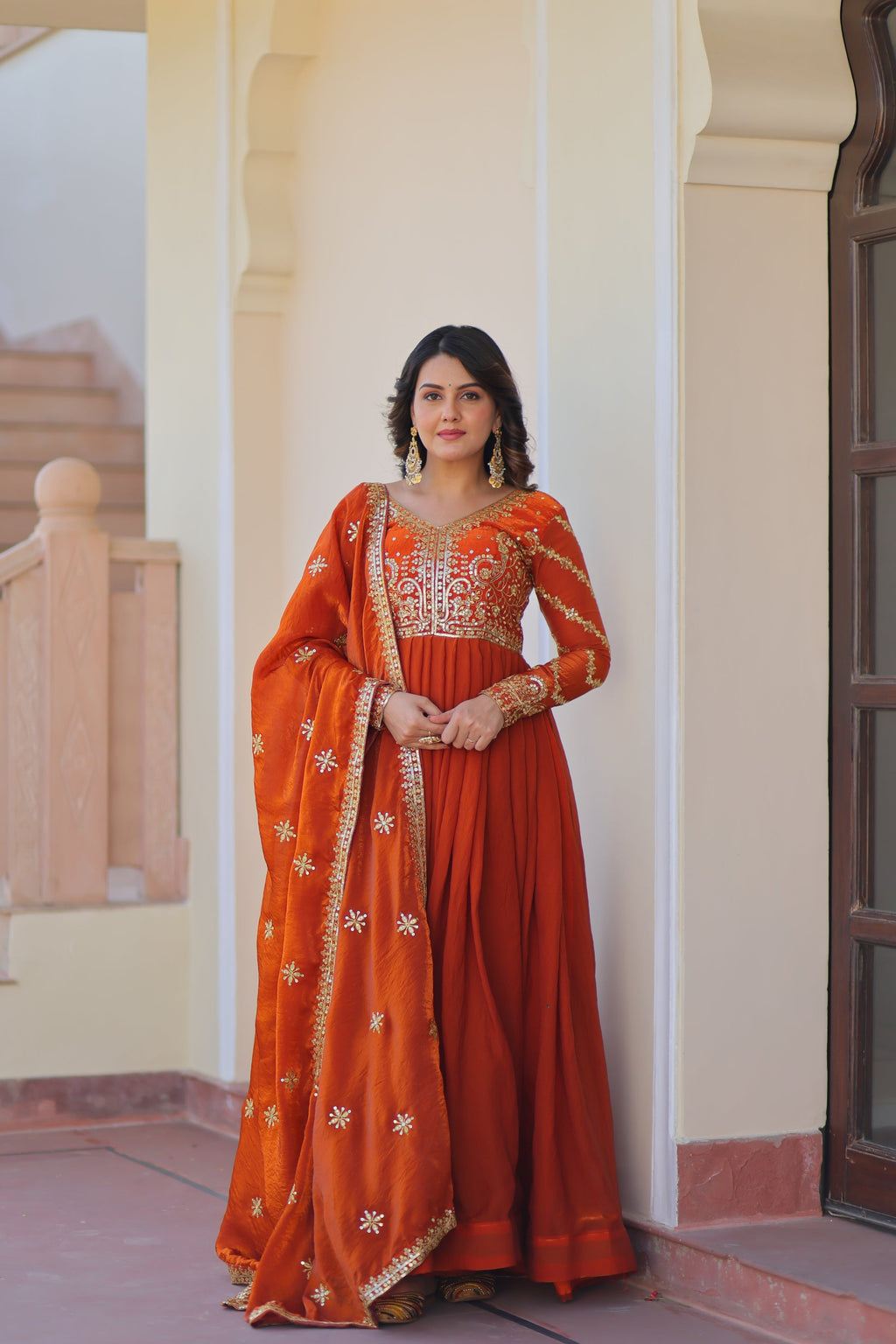 Varnita Orange Gown in Fendy Silk with zari & sequin work, full sleeves, V-neck & dupatta – regal festive wear, fully stitched.