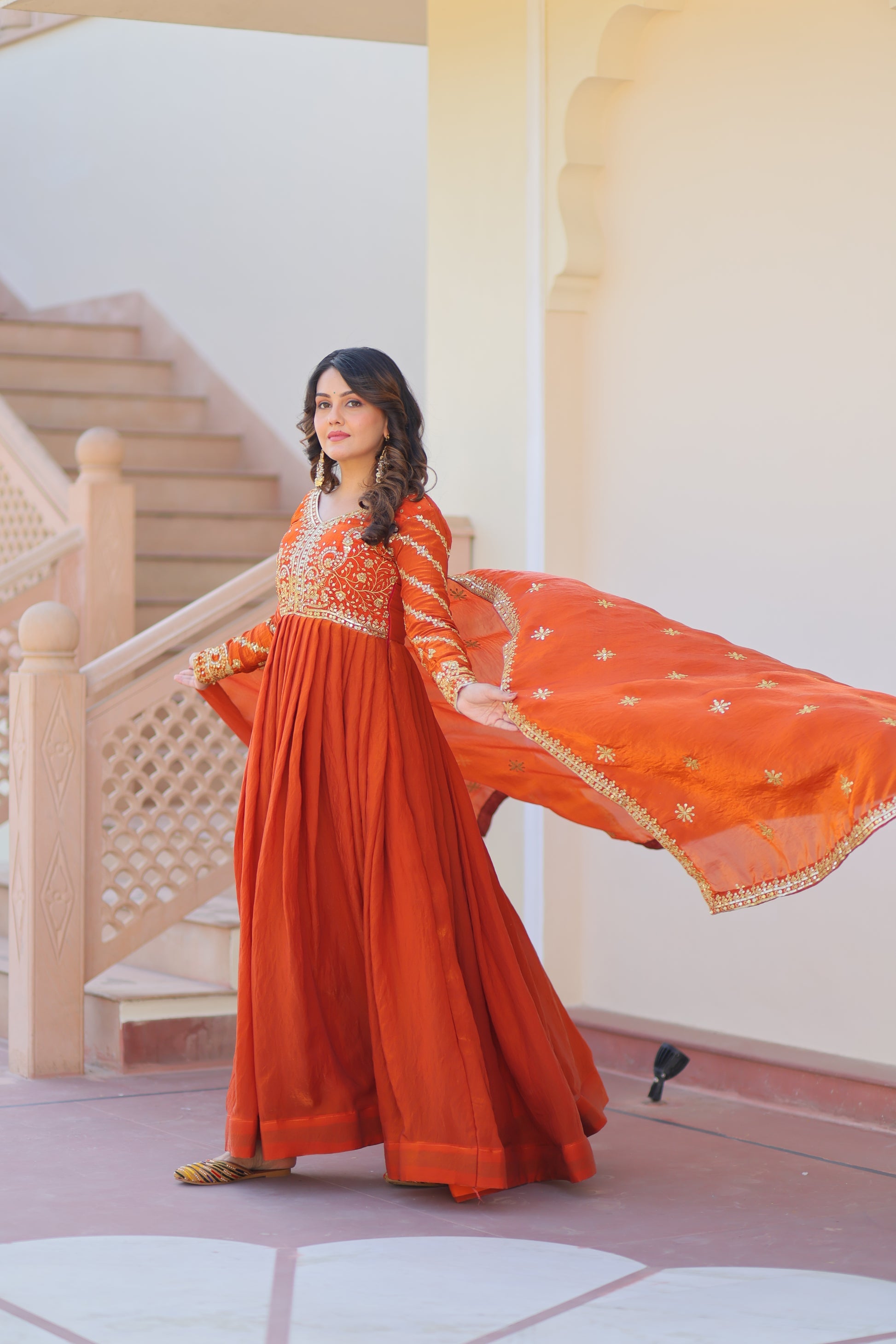 Varnita Orange Gown in Fendy Silk with zari & sequin work, full sleeves, V-neck & dupatta – regal festive wear, fully stitched.
