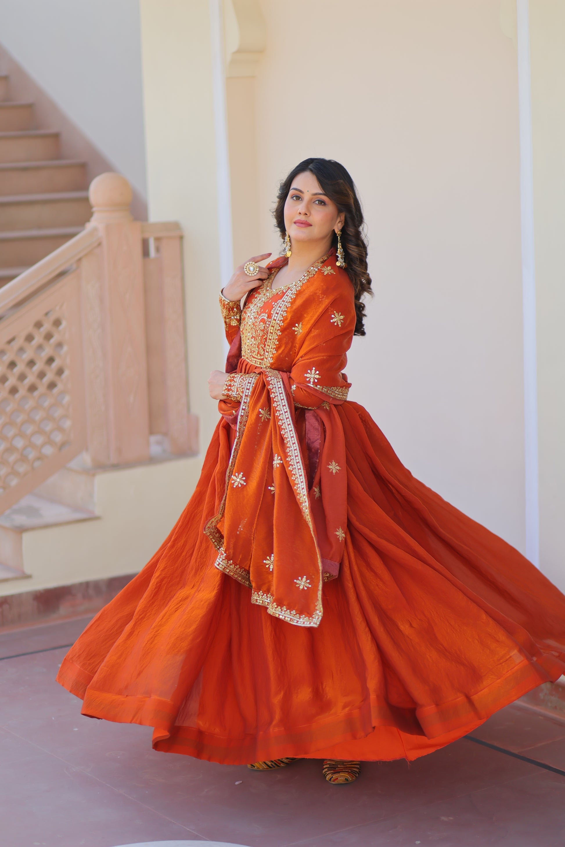 Varnita Orange Gown in Fendy Silk with zari & sequin work, full sleeves, V-neck & dupatta – regal festive wear, fully stitched.