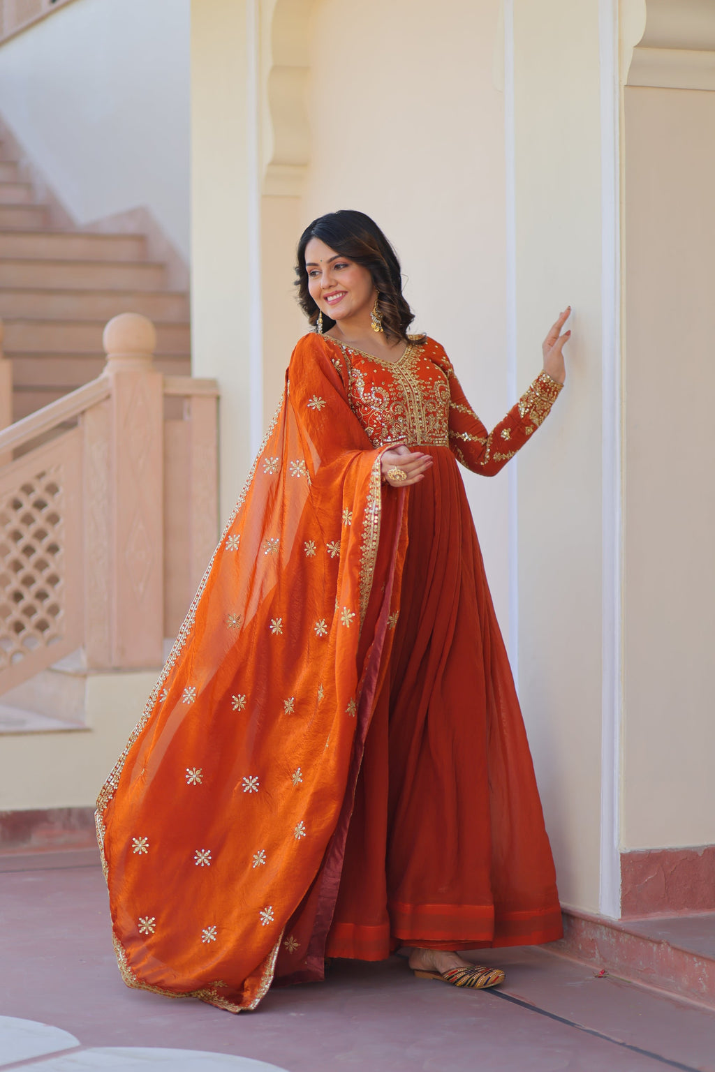 Varnita Orange Gown in Fendy Silk with zari & sequin work, full sleeves, V-neck & dupatta – regal festive wear, fully stitched.