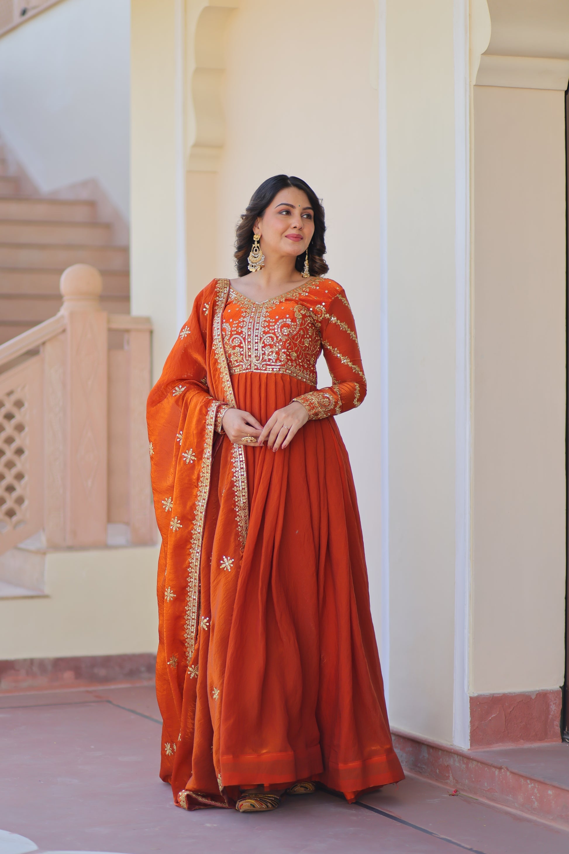 Varnita Orange Gown in Fendy Silk with zari & sequin work, full sleeves, V-neck & dupatta – regal festive wear, fully stitched.