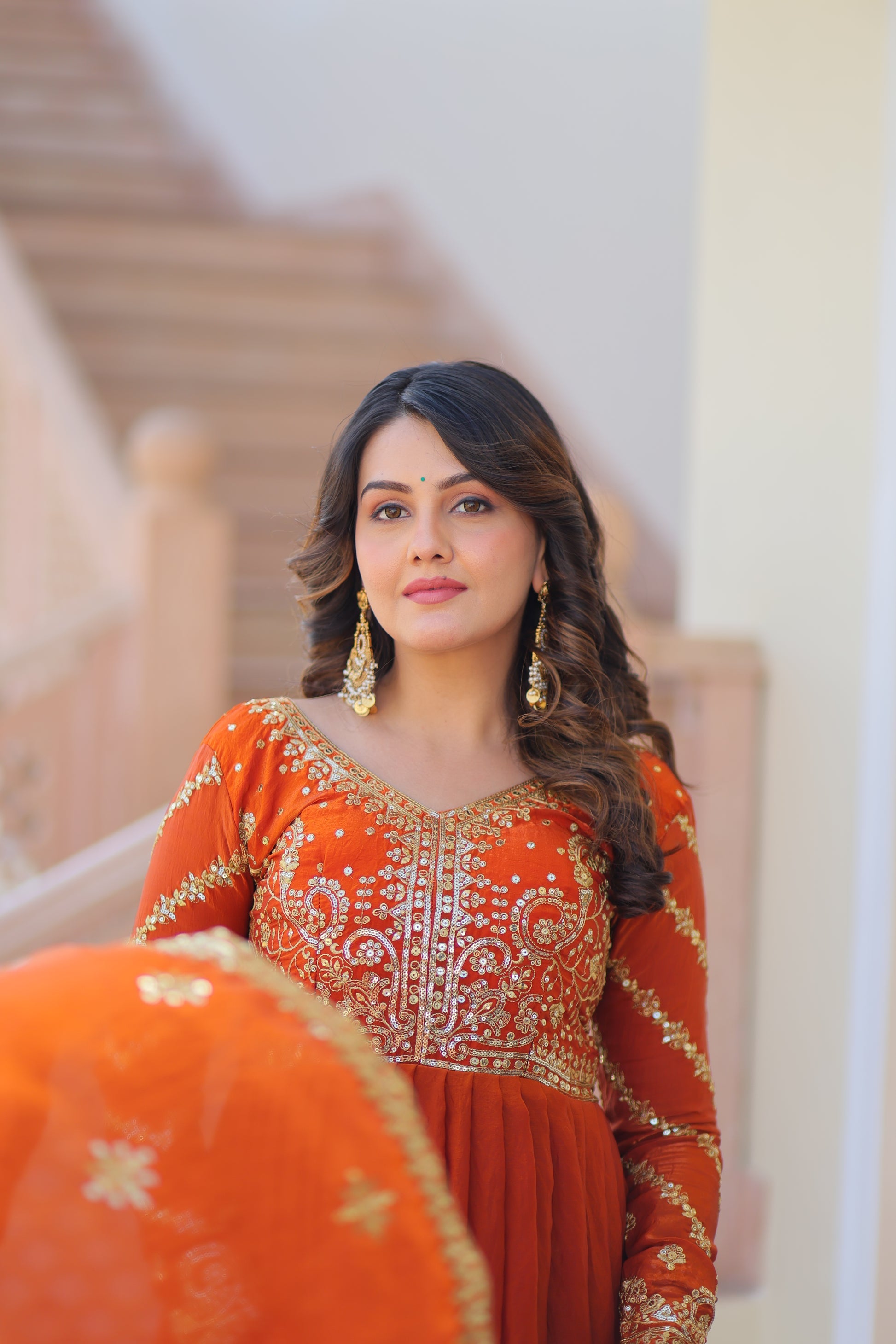 Varnita Orange Gown in Fendy Silk with zari & sequin work, full sleeves, V-neck & dupatta – regal festive wear, fully stitched.