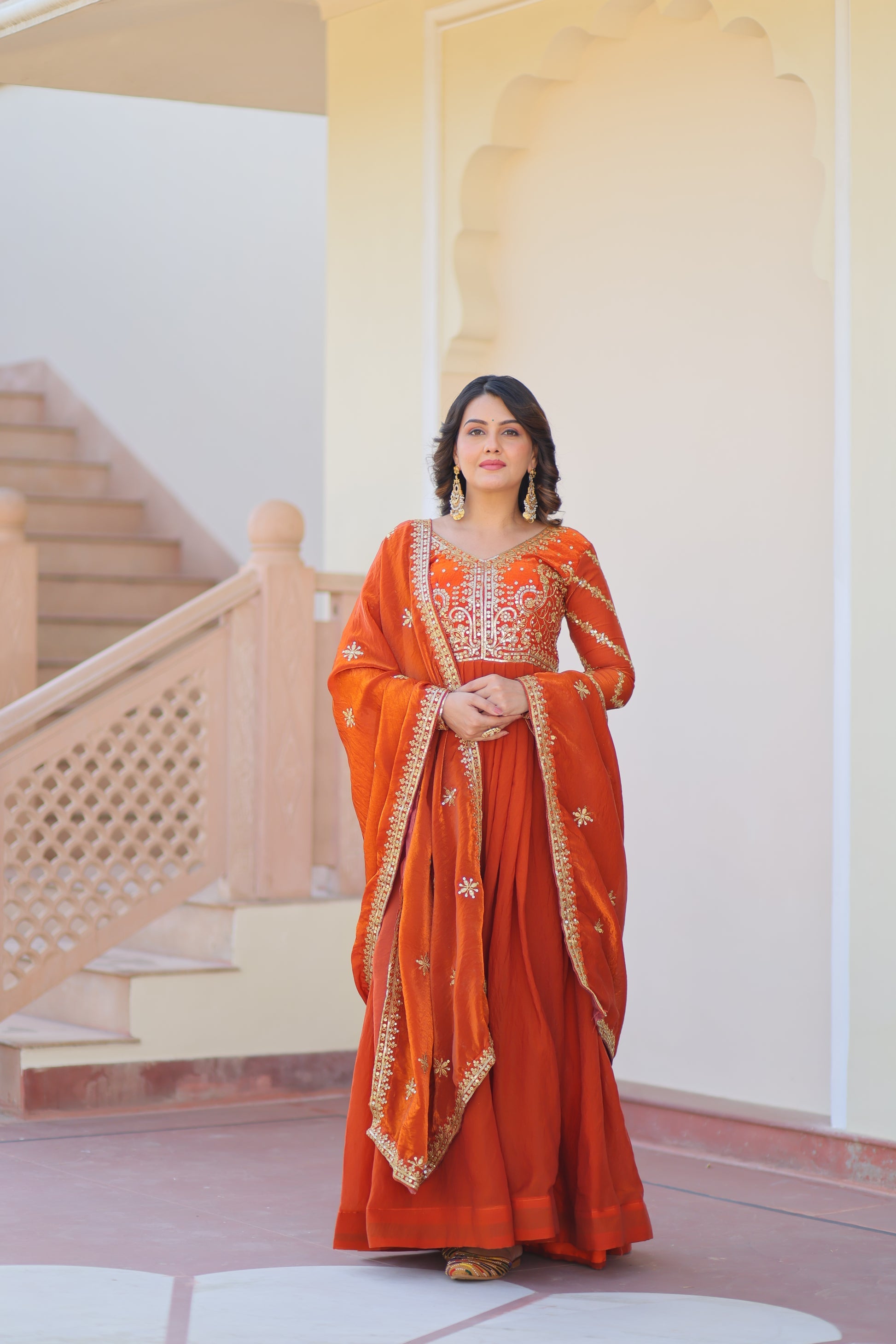 Varnita Orange Gown in Fendy Silk with zari & sequin work, full sleeves, V-neck & dupatta – regal festive wear, fully stitched.