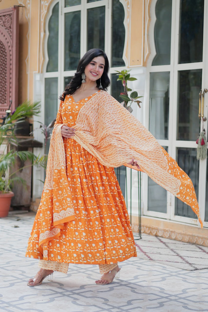 The Ridhvini Orange Pure Cotton Printed Anarkali Set is a stylish and breathable cotton Anarkali suit for women, perfect for daily wear, office wear, and festive occasions. Made from premium pure cotton, this readymade Anarkali kurta set offers comfort and elegance with a flowing silhouette, fancy V-neck, and full sleeves. Paired with straight cotton pants and a matching dupatta, this ethnic cotton suit is ideal for summer fashion. Whether you're looking for a lightweight festive outfit or a printed Anarkal