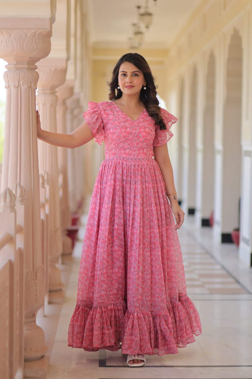 Printed pink georgette gown for women with 7-meter flair, bell sleeves & V-neck—lightweight ethnic dress for Haldi, Mehendi, Navratri & festive functions.