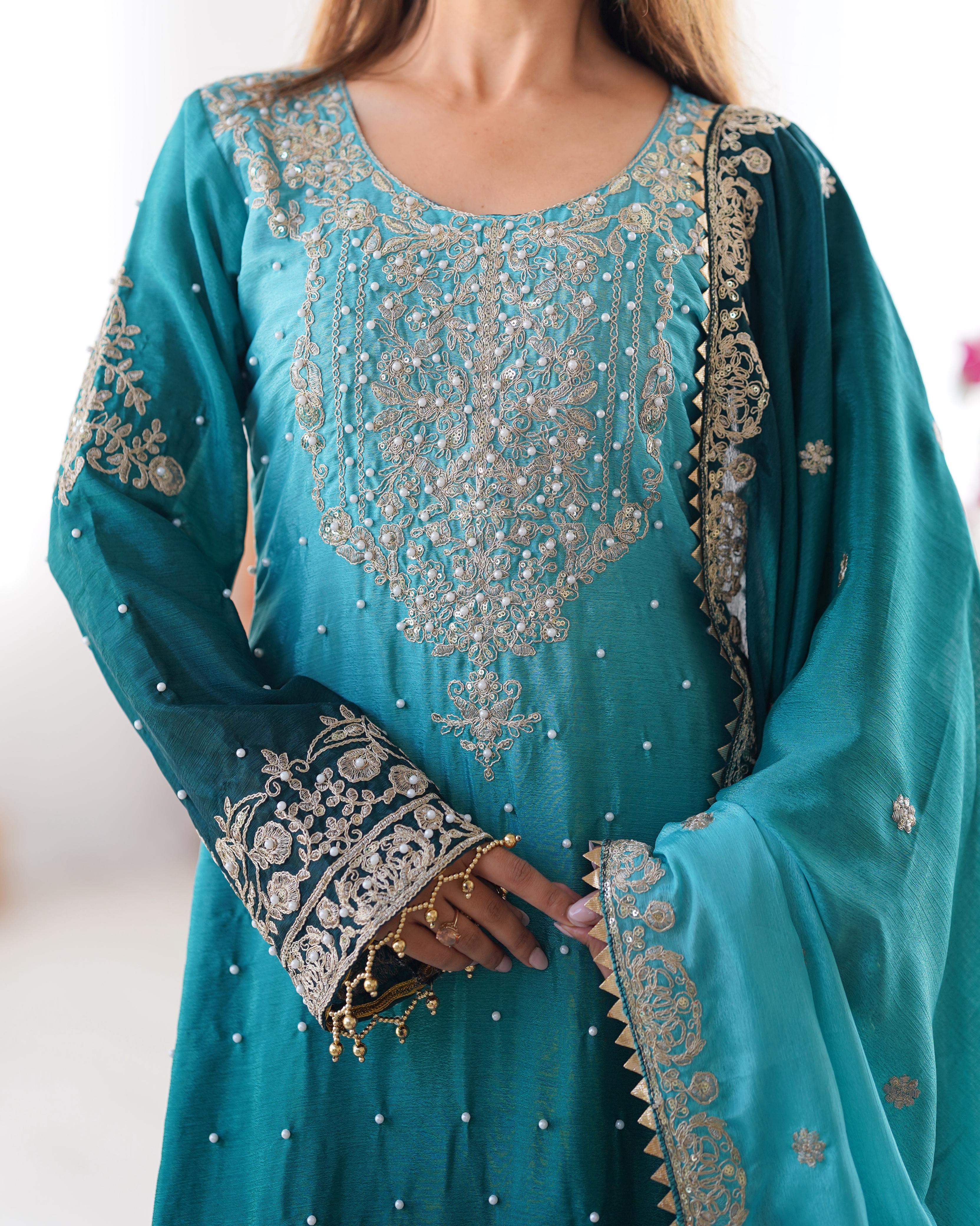 This Manvisha Teal Embroidered Sharara Suit Set is an exquisite choice for wedding wear, festive outfits, and partywear sharara suits. Crafted from premium Chinon silk, this designer sharara set features intricate cording dori embroidery, sequins work, and rivet moti detailing, making it an elegant addition to any ethnic wardrobe. The fully stitched embroidered kurta with front and back detailing pairs beautifully with designer sharara pants featuring an elastic waistband for comfort. Completing the ensembl