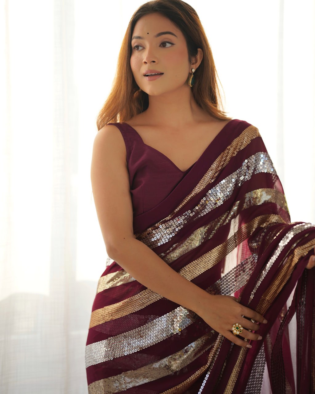 Kira Wine Georgette Saree with 3MM to 7MM sequin embroidery, elegant lining pattern and mono Banglory blouse – ideal sequin saree for wedding receptions, cocktail parties, festive wear, and premium Bollywood-style designer look.