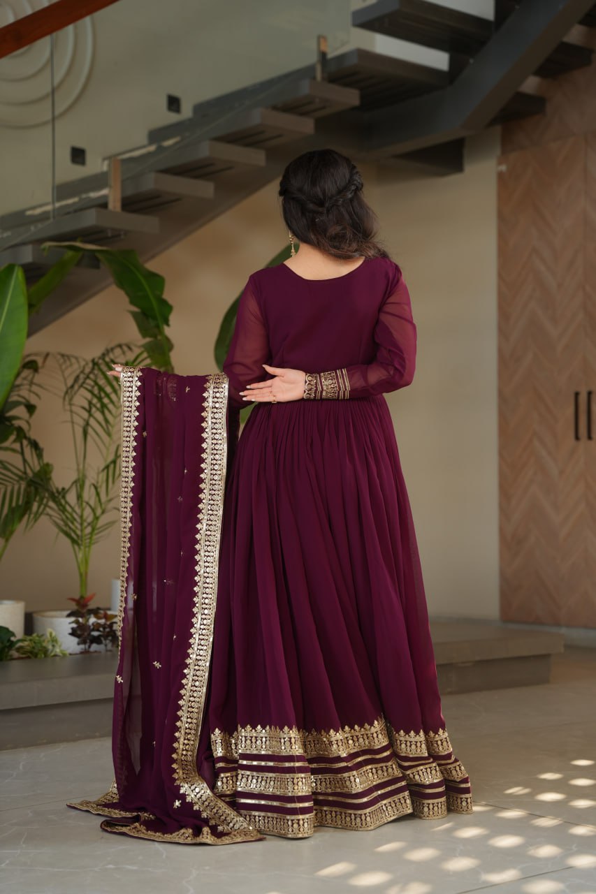Sampriti Wine Embroidered Gown Set – wine color gown with dupatta, zari sequin ethnic gown, faux blooming fabric gown for women, V-neck partywear gown, wedding guest long gown, Indian embroidered gown dress, full sleeve flair gown, bridal festive ethnic outfit, designer wine Anarkali gown, fully stitched traditional gown.