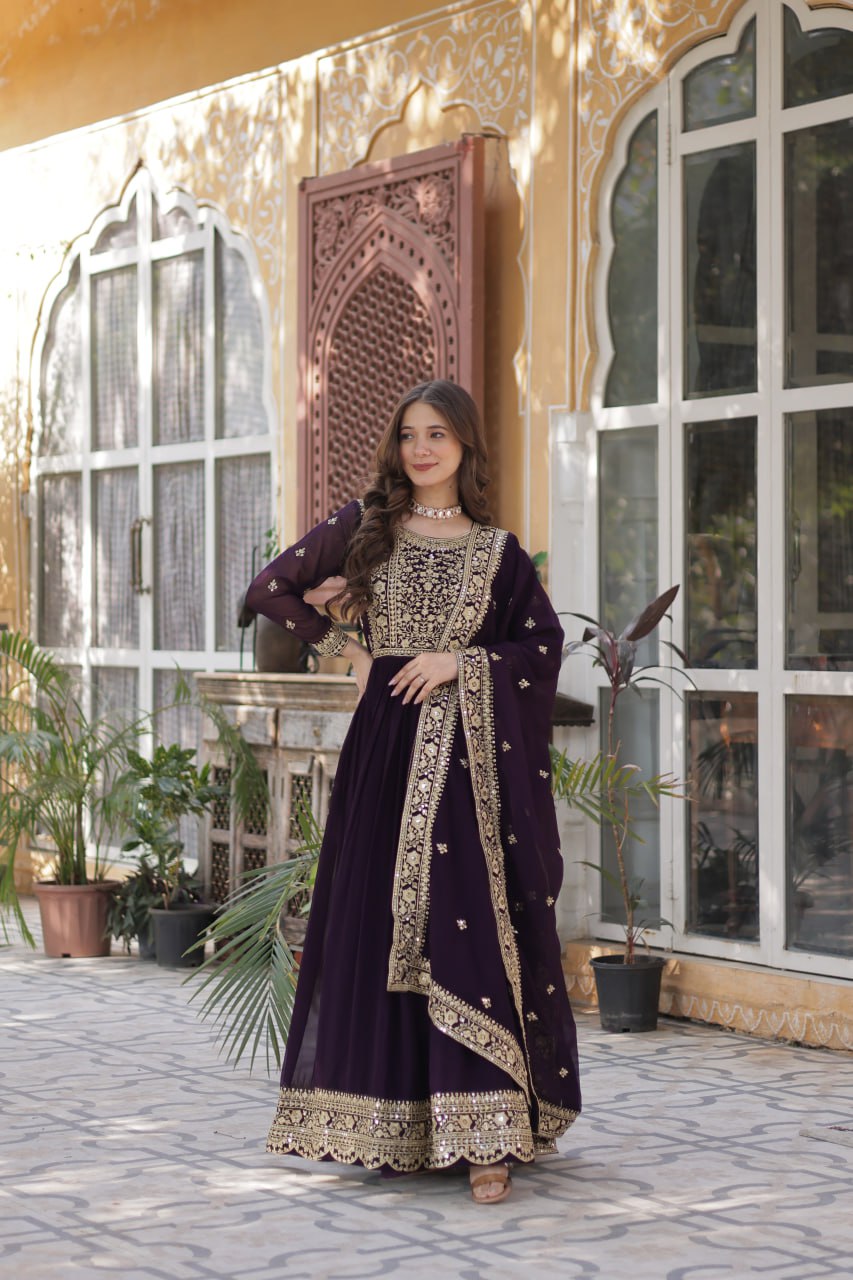 Suvarnita wine embroidered ethnic gown set with zari and sequin work, featuring full sleeves, round neck, flared 56-inch faux blooming gown and matching dupatta – ideal Indian party wear gown for weddings and festive occasions.
