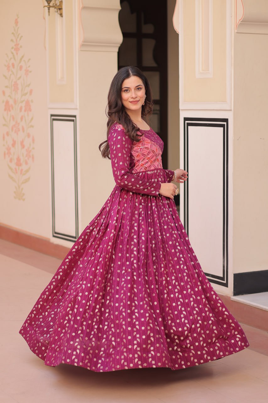 Vani Choli Printed Wine Color Gown with staple jacquard fabric, full sleeves, cotton lining, and 3-meter flare – perfect ethnic party wear gown for wedding functions, festive nights, and modern Indian women.