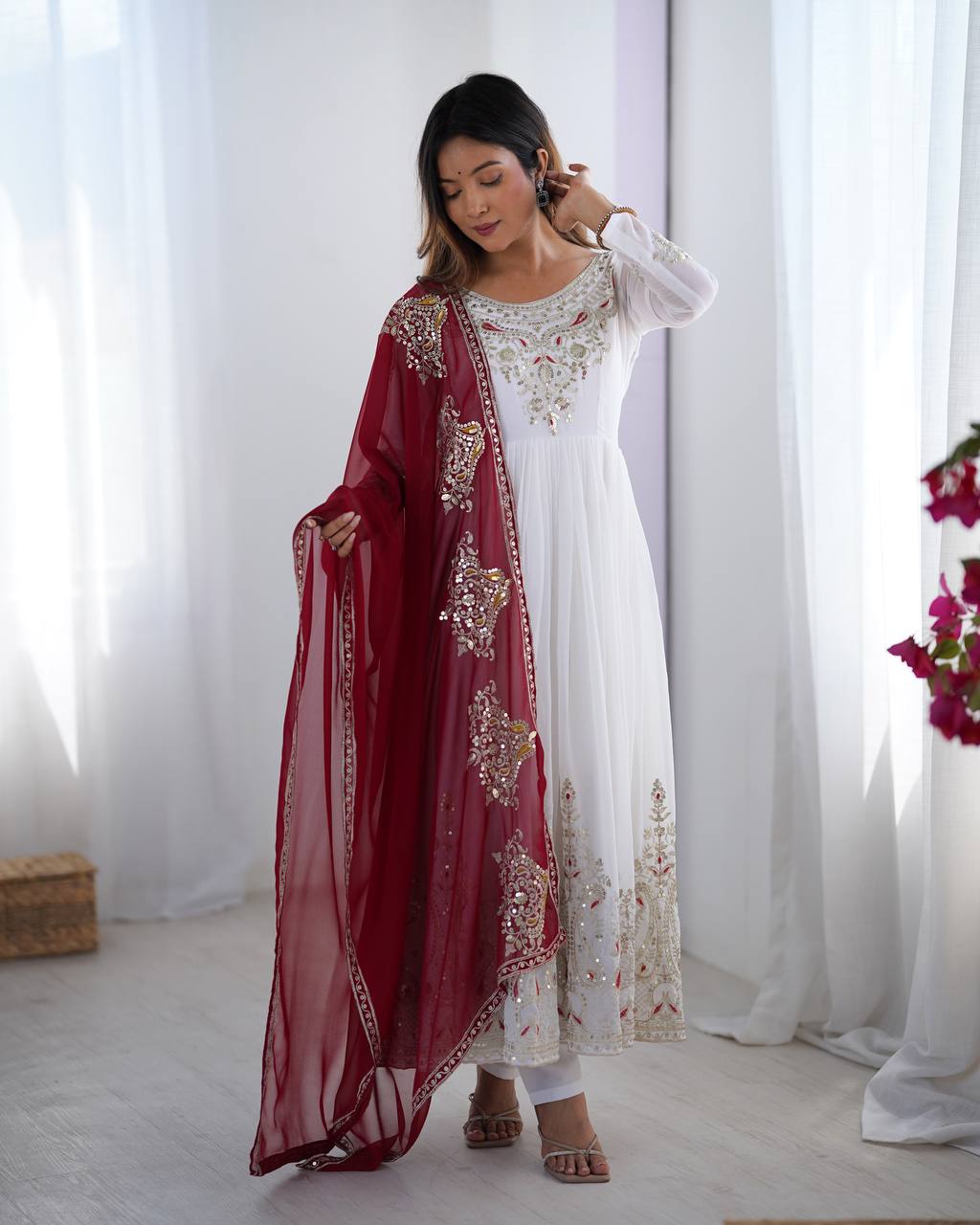 Tejvini White Embroidered Gown Set – heavy georgette gown with multi-thread 5mm sequin embroidery, full sleeves, soft cotton inner, paired with contrasting maroon embroidered dupatta and stitched bottom – ideal for weddings, receptions, and festive occasions.
