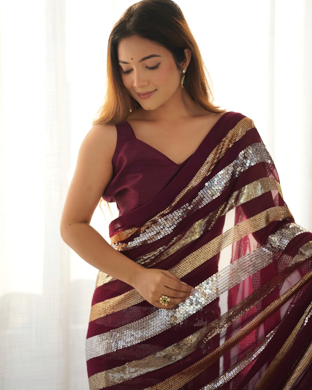 Kira Wine Georgette Saree with 3MM to 7MM sequin embroidery, elegant lining pattern and mono Banglory blouse – ideal sequin saree for wedding receptions, cocktail parties, festive wear, and premium Bollywood-style designer look.