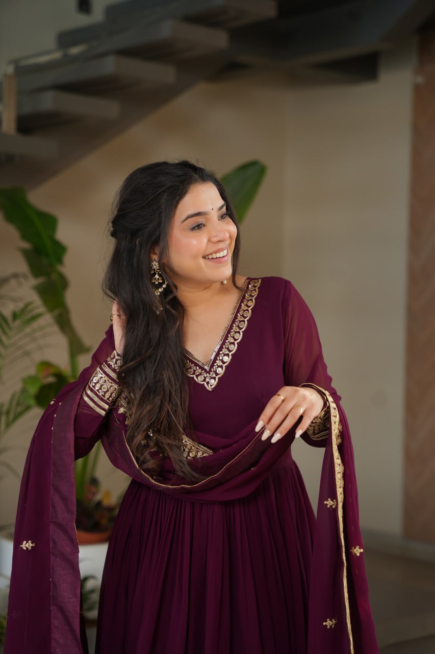 Sampriti Wine Embroidered Gown Set – wine color gown with dupatta, zari sequin ethnic gown, faux blooming fabric gown for women, V-neck partywear gown, wedding guest long gown, Indian embroidered gown dress, full sleeve flair gown, bridal festive ethnic outfit, designer wine Anarkali gown, fully stitched traditional gown.