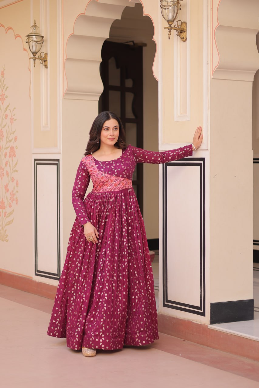 Vani Choli Printed Wine Color Gown with staple jacquard fabric, full sleeves, cotton lining, and 3-meter flare – perfect ethnic party wear gown for wedding functions, festive nights, and modern Indian women.