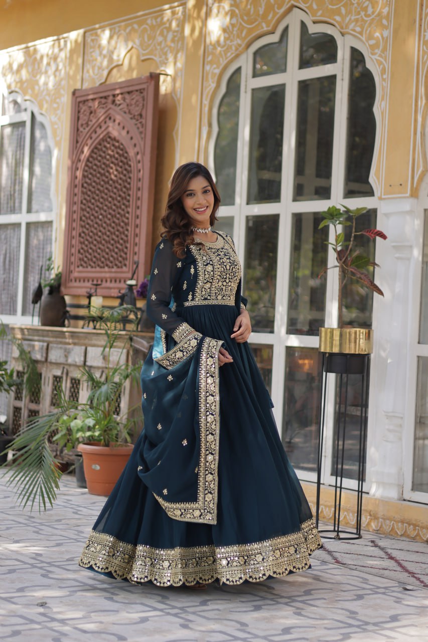  Suvarnita teal embroidered ethnic gown set with zari and sequin work, featuring full sleeves, round neck, flared 56-inch faux blooming gown and matching dupatta – ideal Indian party wear gown for weddings and festive occasions.