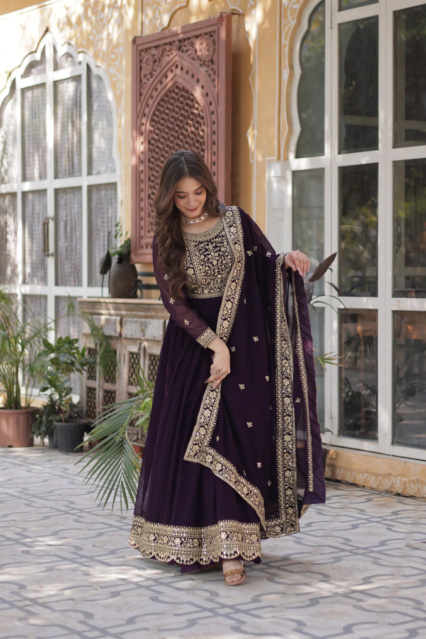 Suvarnita wine embroidered ethnic gown set with zari and sequin work, featuring full sleeves, round neck, flared 56-inch faux blooming gown and matching dupatta – ideal Indian party wear gown for weddings and festive occasions.