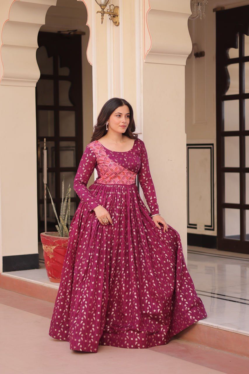 Vani Choli Printed Wine Color Gown with staple jacquard fabric, full sleeves, cotton lining, and 3-meter flare – perfect ethnic party wear gown for wedding functions, festive nights, and modern Indian women.