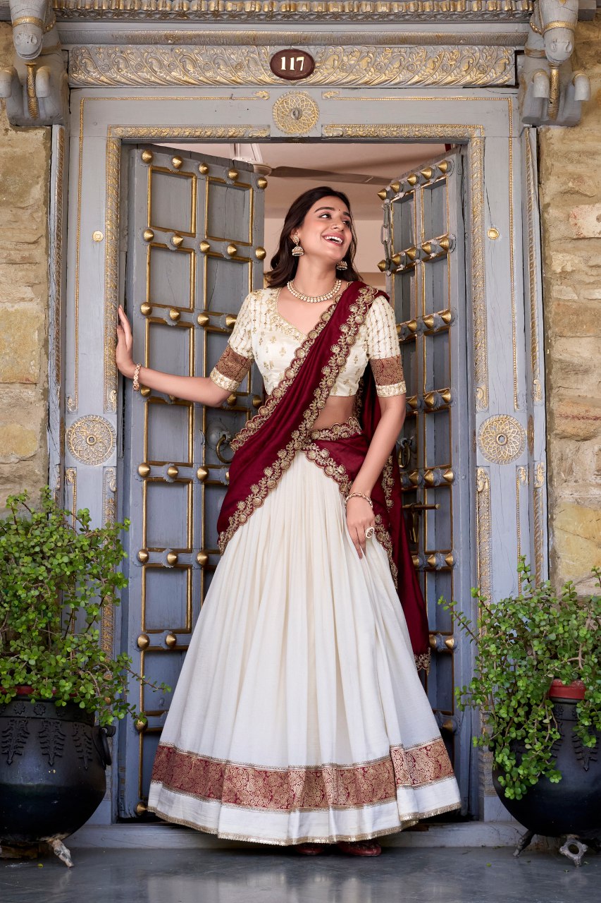 Off-white Vichitra silk lehenga choli set featuring zari weaving, sequins lace border, and embroidered dupatta ideal for weddings and festive celebrations.