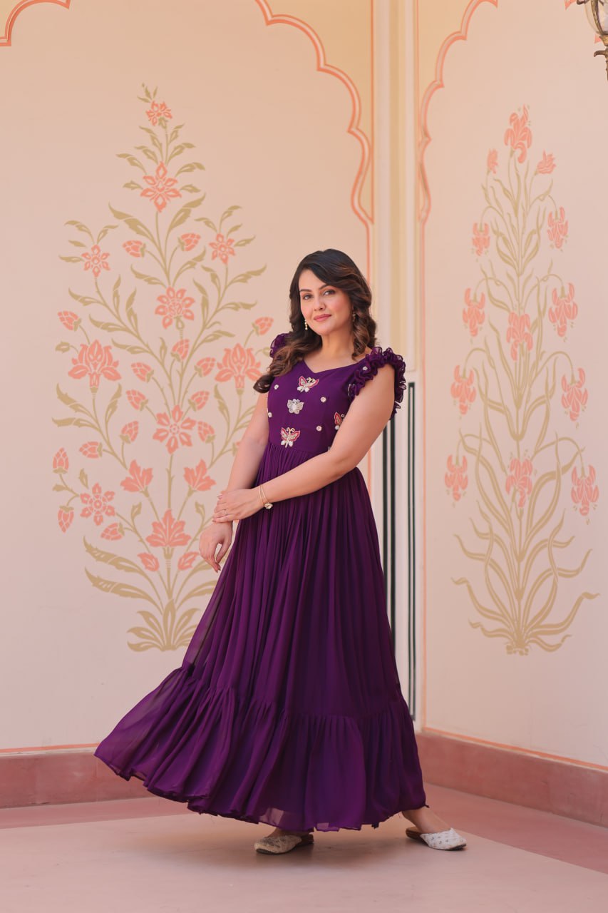 Lavi 7-meter flared designer gown in faux blooming fabric with sequin & bead embroidery, V-neck & frill shoulders – perfect for weddings & parties.