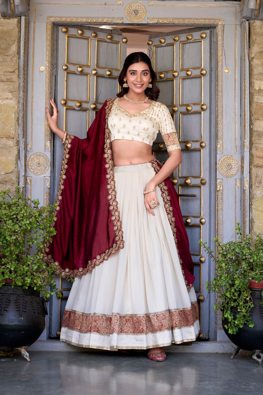 Off-white Vichitra silk lehenga choli set featuring zari weaving, sequins lace border, and embroidered dupatta ideal for weddings and festive celebrations.