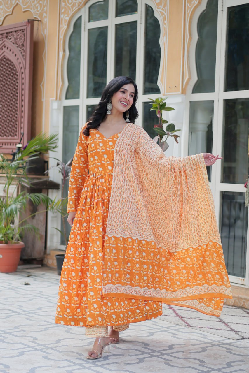 The Ridhvini Orange Pure Cotton Printed Anarkali Set is a stylish and breathable cotton Anarkali suit for women, perfect for daily wear, office wear, and festive occasions. Made from premium pure cotton, this readymade Anarkali kurta set offers comfort and elegance with a flowing silhouette, fancy V-neck, and full sleeves. Paired with straight cotton pants and a matching dupatta, this ethnic cotton suit is ideal for summer fashion. Whether you're looking for a lightweight festive outfit or a printed Anarkal