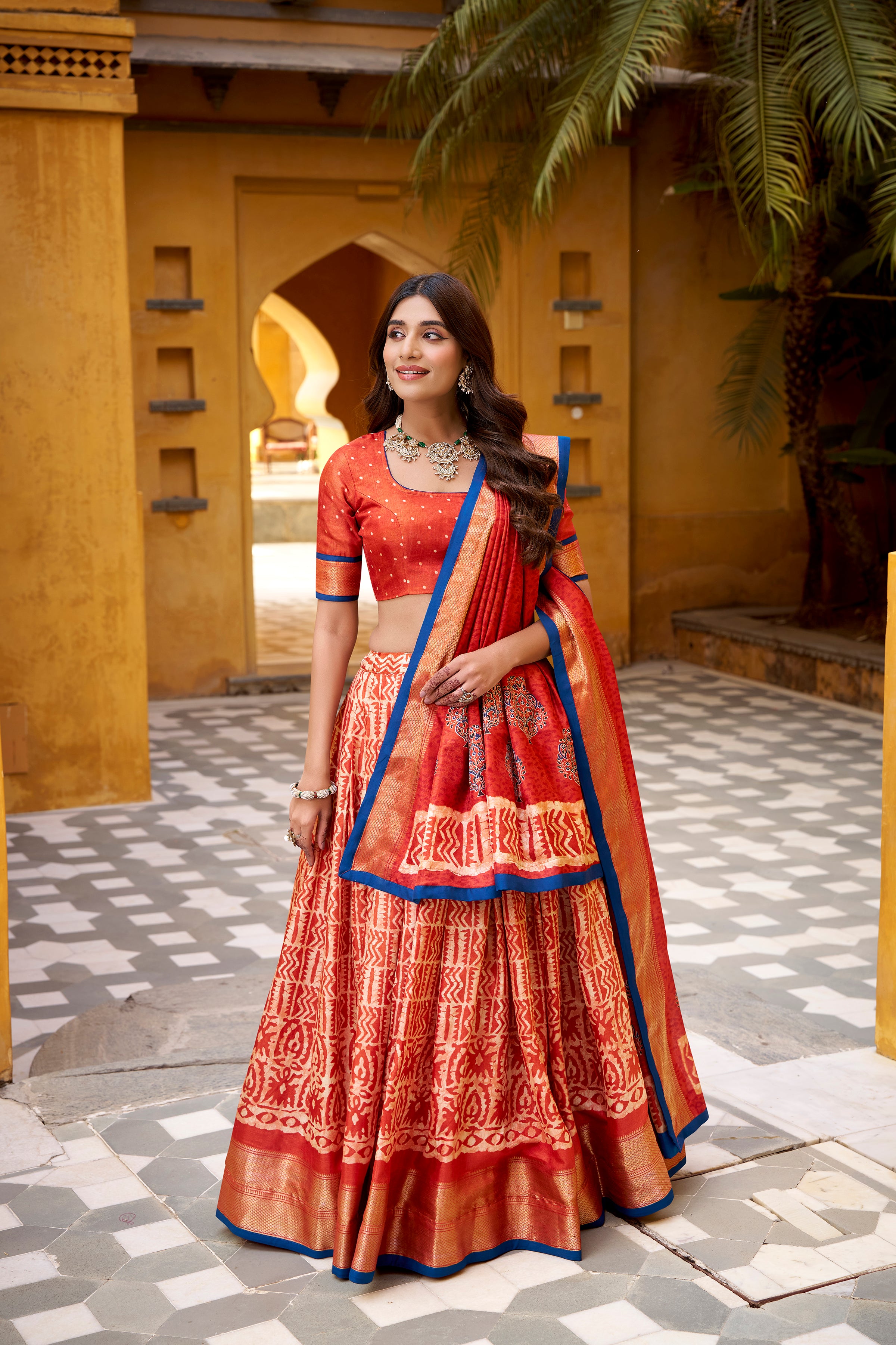 Girija Rust Orange Dola Silk Batik Print With Zari
Weaving Work Lehenga Choli