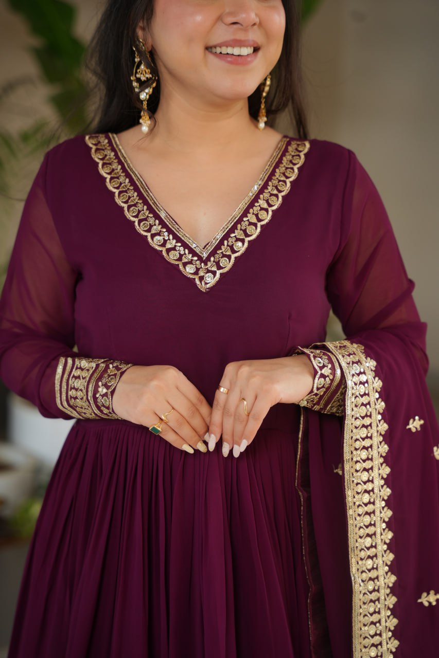 Sampriti Wine Embroidered Gown Set – wine color gown with dupatta, zari sequin ethnic gown, faux blooming fabric gown for women, V-neck partywear gown, wedding guest long gown, Indian embroidered gown dress, full sleeve flair gown, bridal festive ethnic outfit, designer wine Anarkali gown, fully stitched traditional gown.