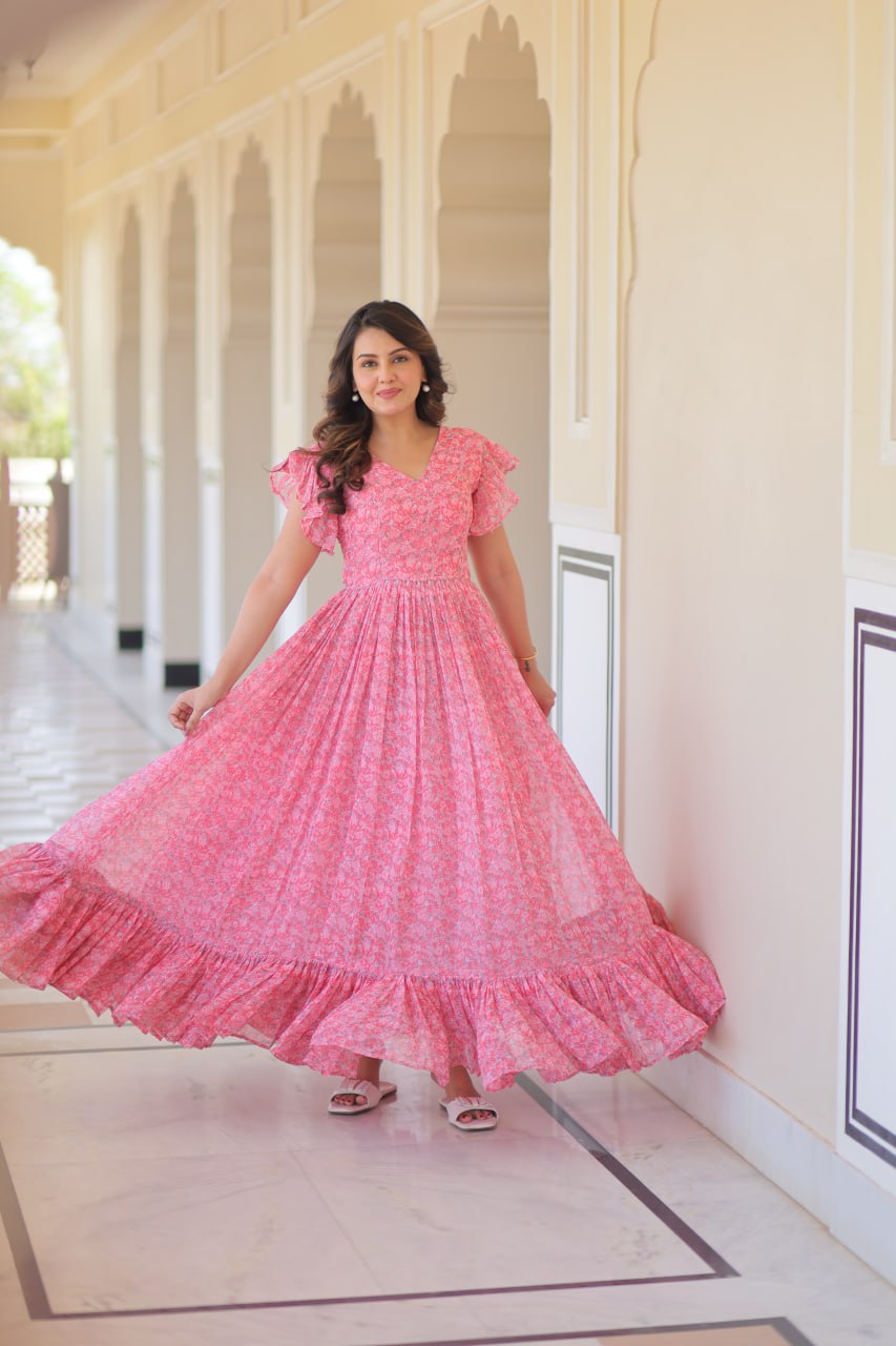 Printed pink georgette gown for women with 7-meter flair, bell sleeves & V-neck—lightweight ethnic dress for Haldi, Mehendi, Navratri & festive functions.