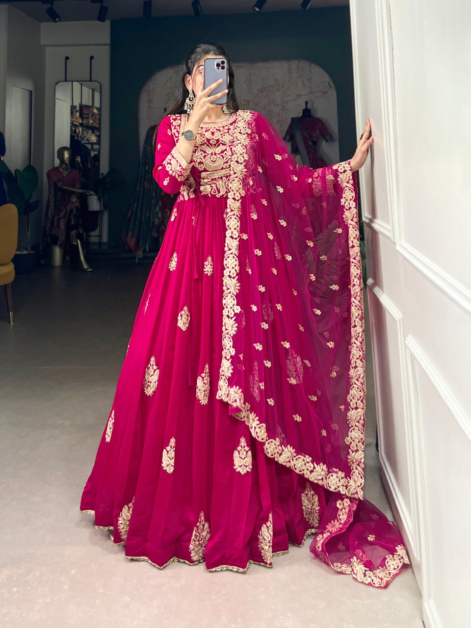 Anwitha Pink Embroidered Silk Anarkali Gown Set, crafted from luxurious Vichitra Silk with intricate sequins and thread embroidery accented by delicate lace details. This fully stitched Anarkali gown features a 3-meter flair and a soft cotton lining for comfort. Paired with a graceful net dupatta adorned with sequins embroidery and a lace border, this elegant ensemble is perfect for weddings, festive occasions, and grand celebrations