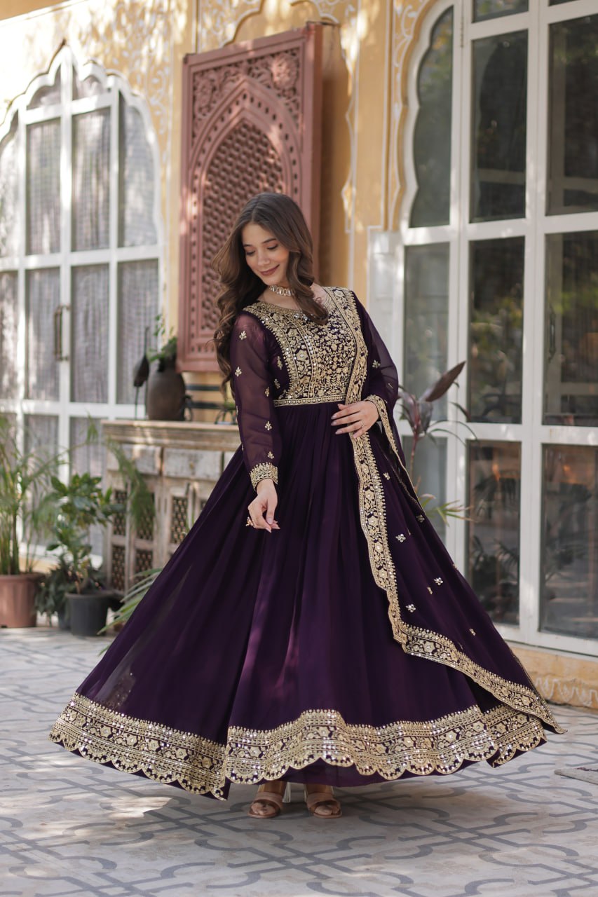 Suvarnita wine embroidered ethnic gown set with zari and sequin work, featuring full sleeves, round neck, flared 56-inch faux blooming gown and matching dupatta – ideal Indian party wear gown for weddings and festive occasions.