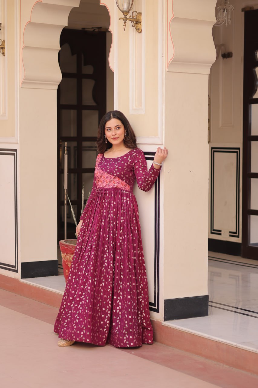 Vani Choli Printed Wine Color Gown with staple jacquard fabric, full sleeves, cotton lining, and 3-meter flare – perfect ethnic party wear gown for wedding functions, festive nights, and modern Indian women.