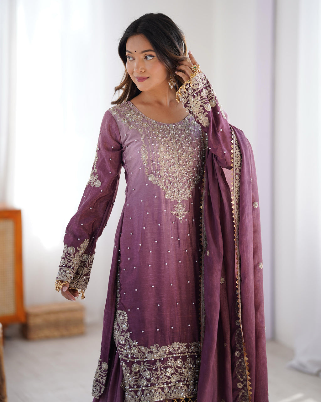 This Manvisha Pink Embroidered Sharara Suit Set is a premium choice for wedding wear, partywear sharara suits, and festive ethnic outfits. Made from luxurious Chinon silk, this designer sharara set features intricate cording dori embroidery, sequins work, and rivet moti detailing, making it perfect for Indian wedding outfits. The fully stitched kurta showcases embroidery on both the front and back, complementing the stylish embroidered sharara pants with an elastic waistband for a comfortable fit. Paired wi