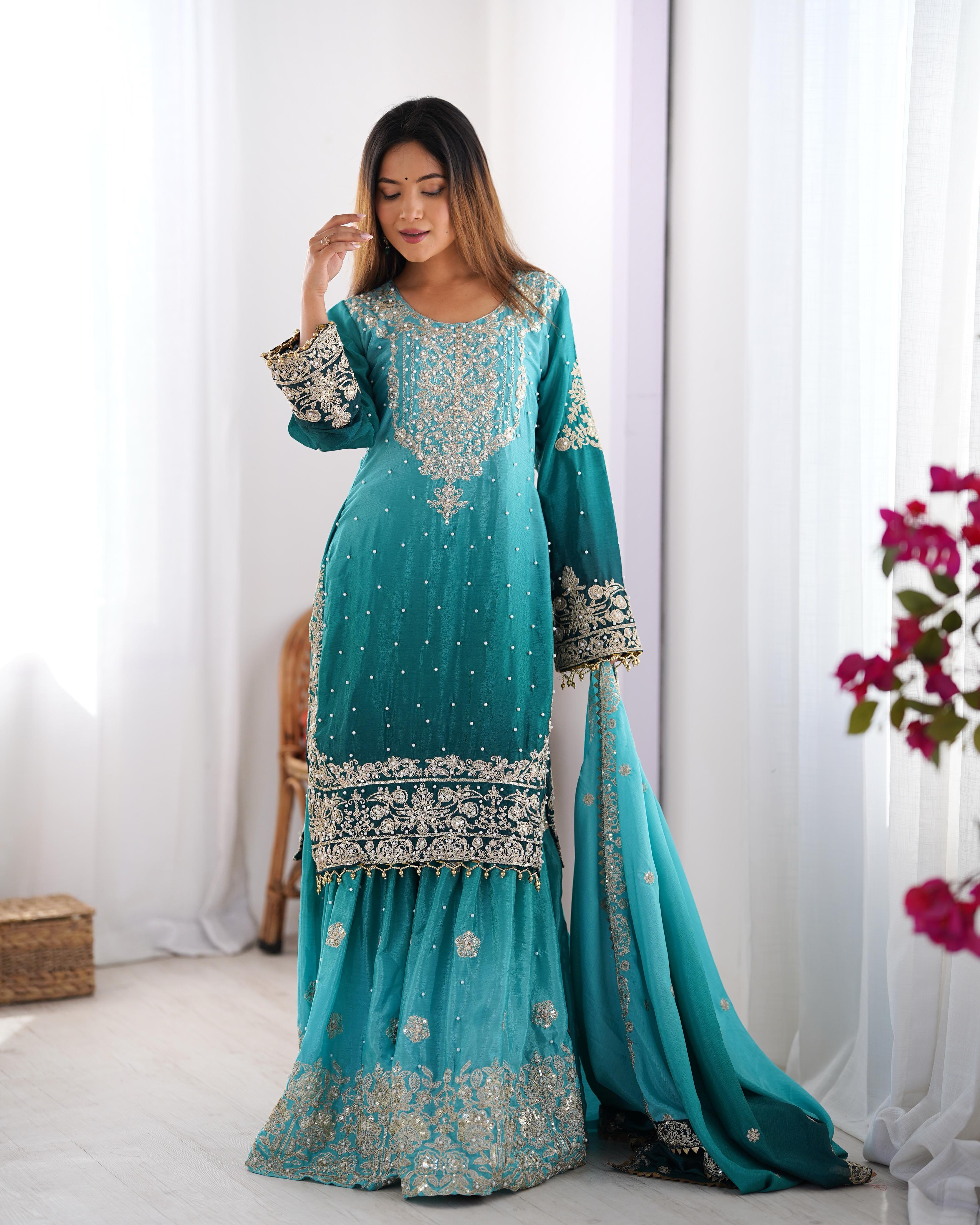 This Manvisha Teal Embroidered Sharara Suit Set is an exquisite choice for wedding wear, festive outfits, and partywear sharara suits. Crafted from premium Chinon silk, this designer sharara set features intricate cording dori embroidery, sequins work, and rivet moti detailing, making it an elegant addition to any ethnic wardrobe. The fully stitched embroidered kurta with front and back detailing pairs beautifully with designer sharara pants featuring an elastic waistband for comfort. Completing the ensembl