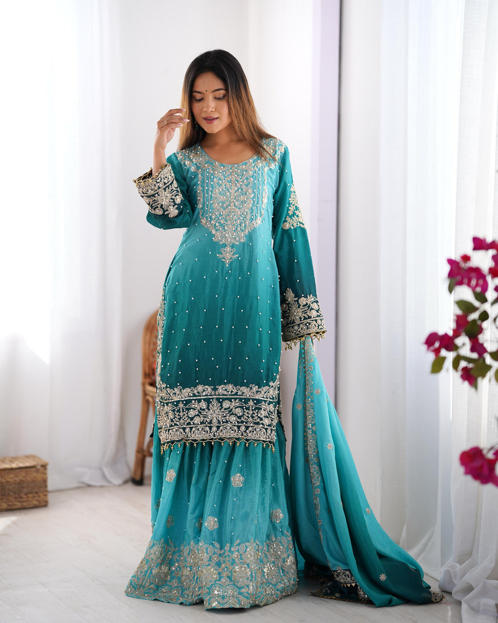 This Manvisha Teal Embroidered Sharara Suit Set is an exquisite choice for wedding wear, festive outfits, and partywear sharara suits. Crafted from premium Chinon silk, this designer sharara set features intricate cording dori embroidery, sequins work, and rivet moti detailing, making it an elegant addition to any ethnic wardrobe. The fully stitched embroidered kurta with front and back detailing pairs beautifully with designer sharara pants featuring an elastic waistband for comfort. Completing the ensembl