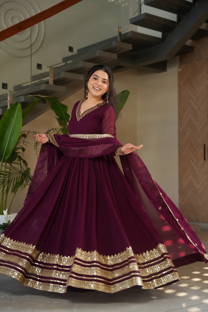 Sampriti Wine Embroidered Gown Set – wine color gown with dupatta, zari sequin ethnic gown, faux blooming fabric gown for women, V-neck partywear gown, wedding guest long gown, Indian embroidered gown dress, full sleeve flair gown, bridal festive ethnic outfit, designer wine Anarkali gown, fully stitched traditional gown.